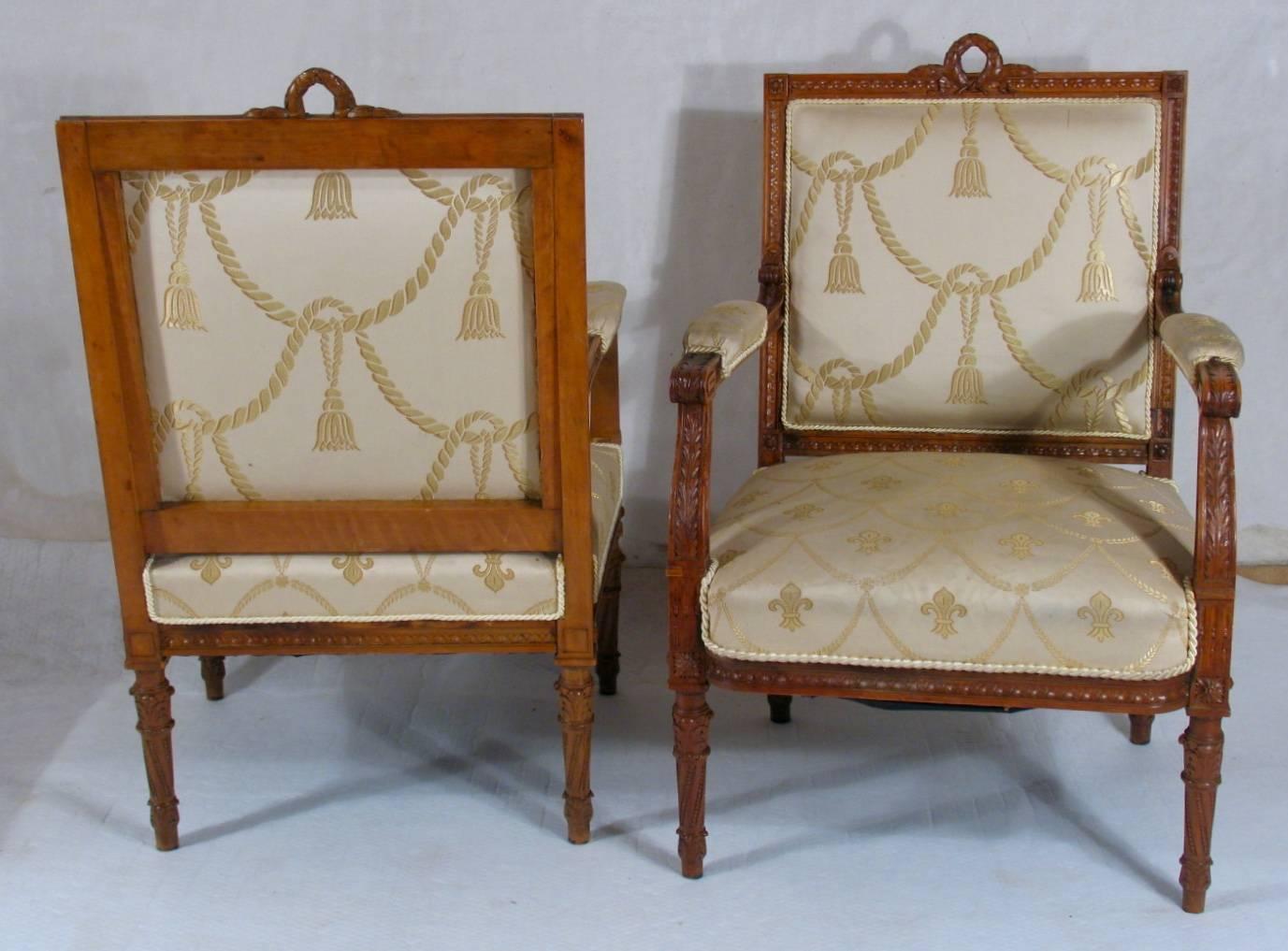 Elaborate pair of Louis XVI-style fauteuils, finely carved pearwood. Straight back crowned with wreath, upholstered seat and back, ending on round tapered baluster legs. Originally the fauteuils belonged to a salon suite composed of one settee and