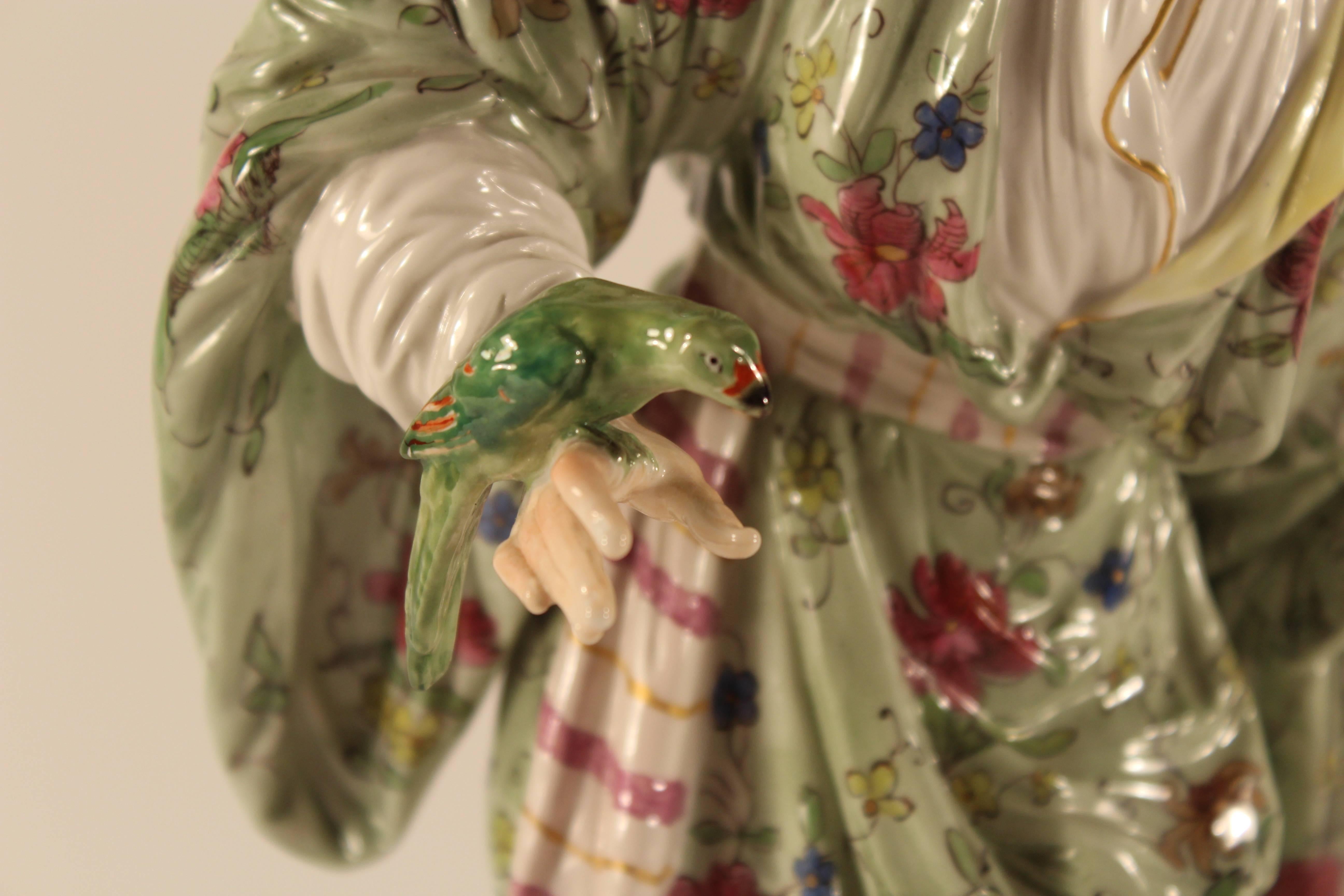 Femme avec un perroquet, KPM Berlin, 19ème siècle...
Belle figurine d'une femme debout en robe orientale tenant un perroquet dans sa main droite. 
Peint de façon naturaliste avec la marque KPM cuite sur le fond.
