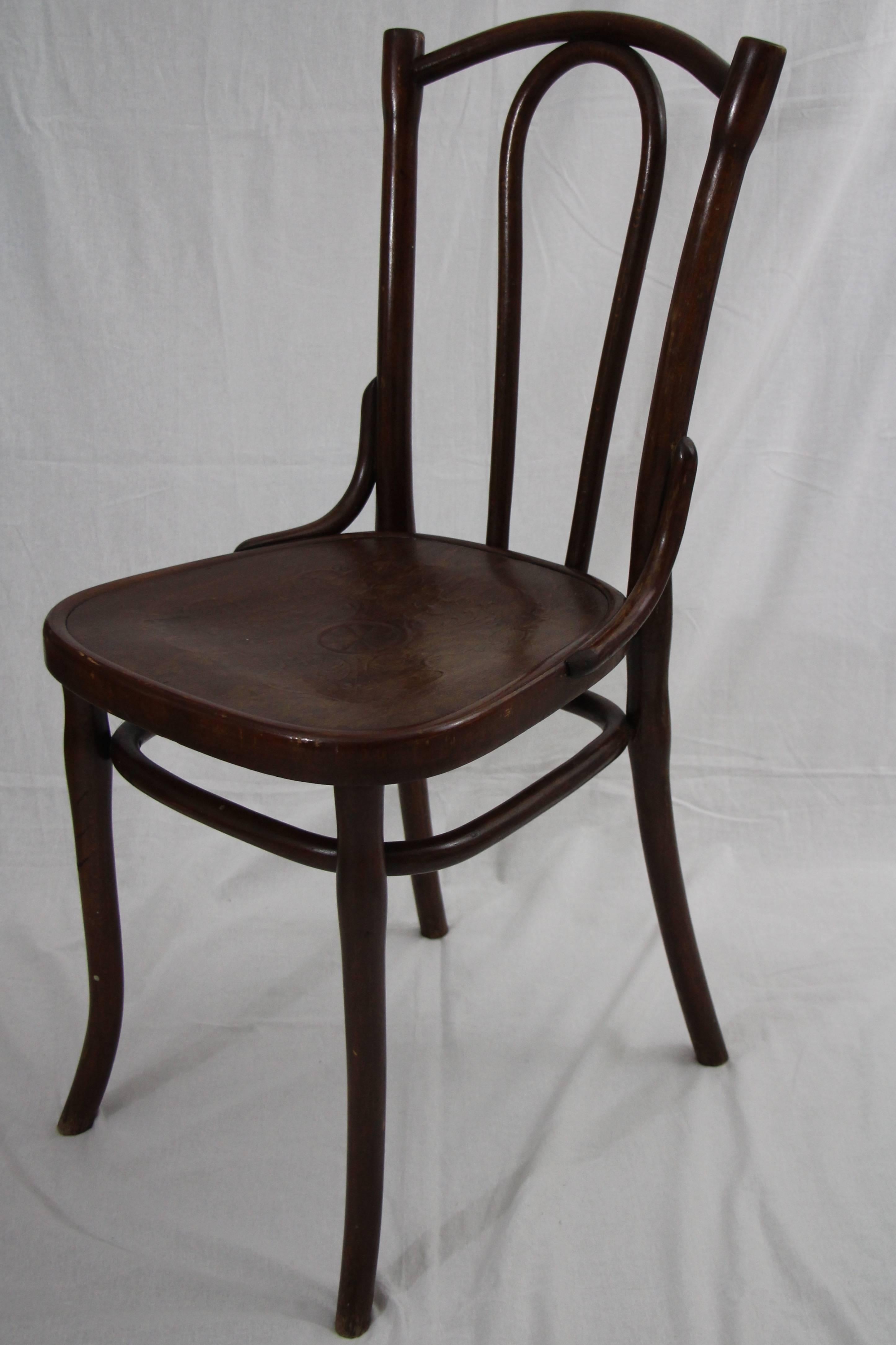 Set of four bentwood coffee house chairs with embossed seats. Produced by Gebrueder Thonet in Vienna, circa 1900. Old Thonet label on the underside.