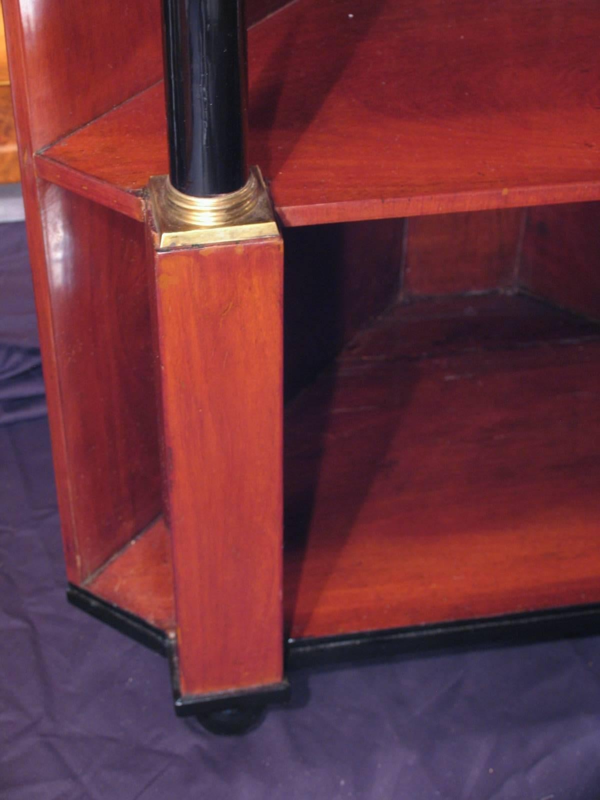 Außergewöhnlicher früher Biedermeier-Eckschrank mit drei offenen Regalen und einer Schublade. Mahagonifurnier mit ebonisierten Säulen und Kapitellen und Sockeln aus Messing. Der Schrank wurde um 1810 in Süddeutschland hergestellt. Es ist wunderschön