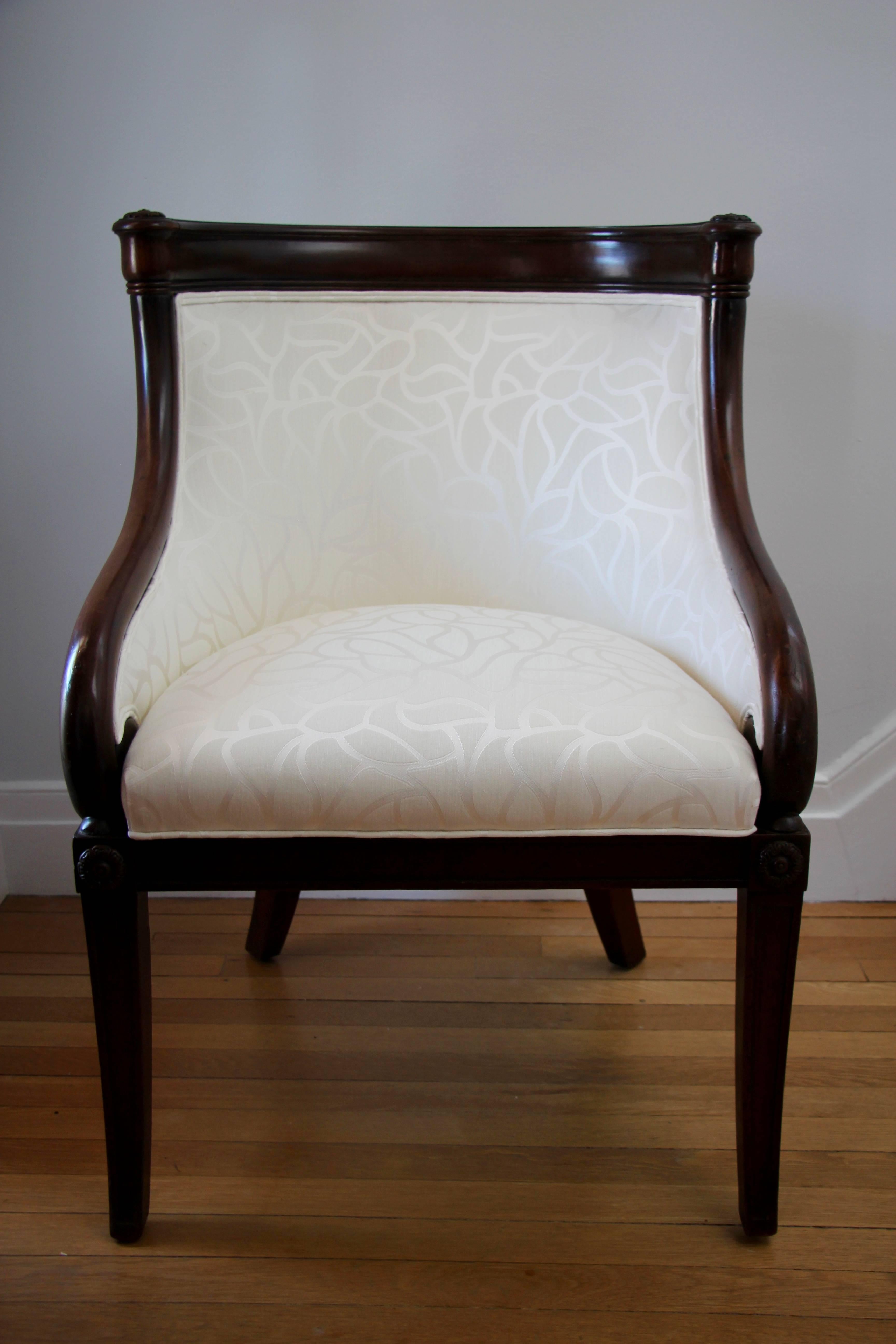 Unique Empire tub armchair, circa 1820, mahogany with finely carved details. Newly upholstered with beautiful crème colored fabric.