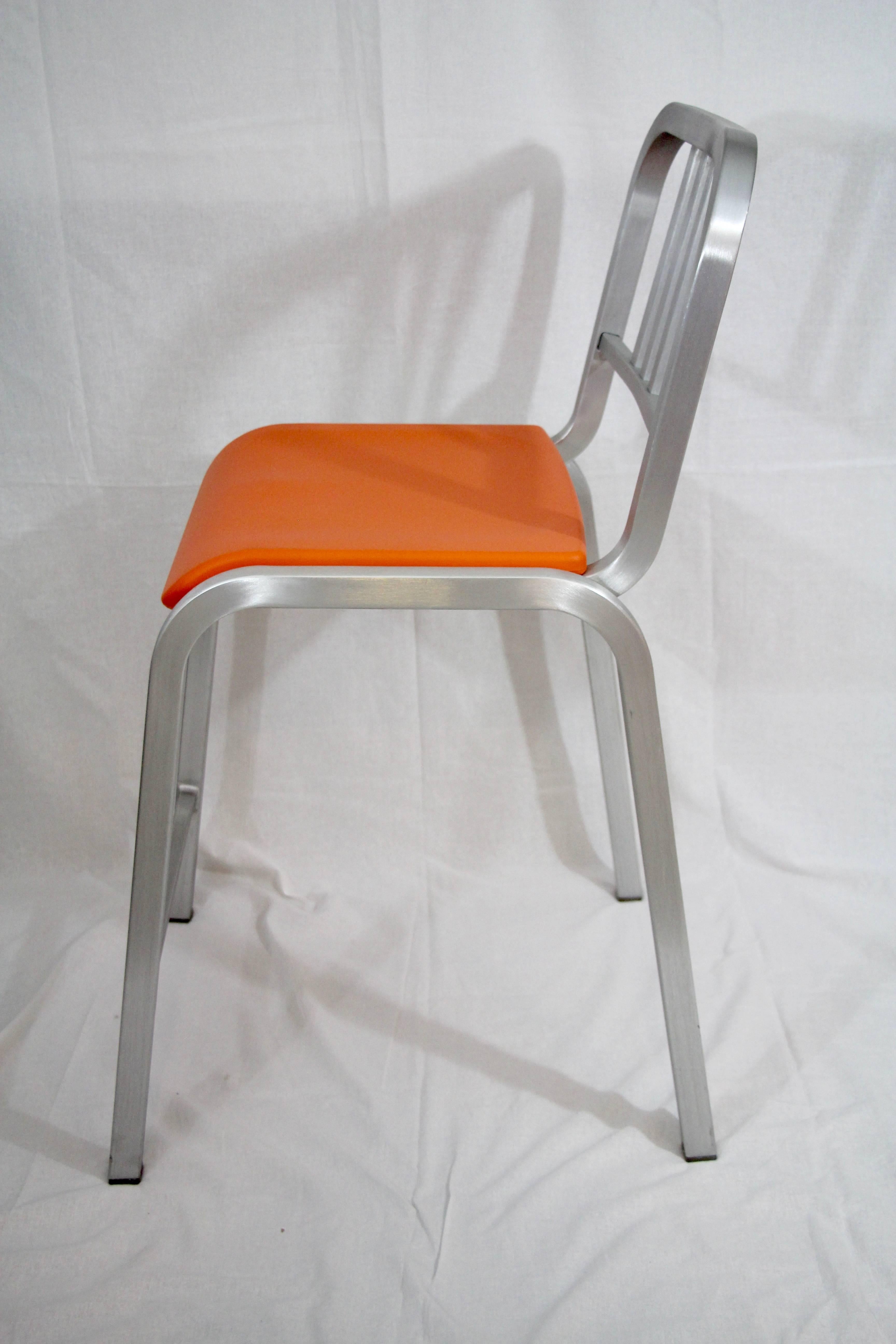 Pair of Emeco bar stools designed by Ettore Sottsass (1917-2007), brushed aluminum with orange plastic seats.