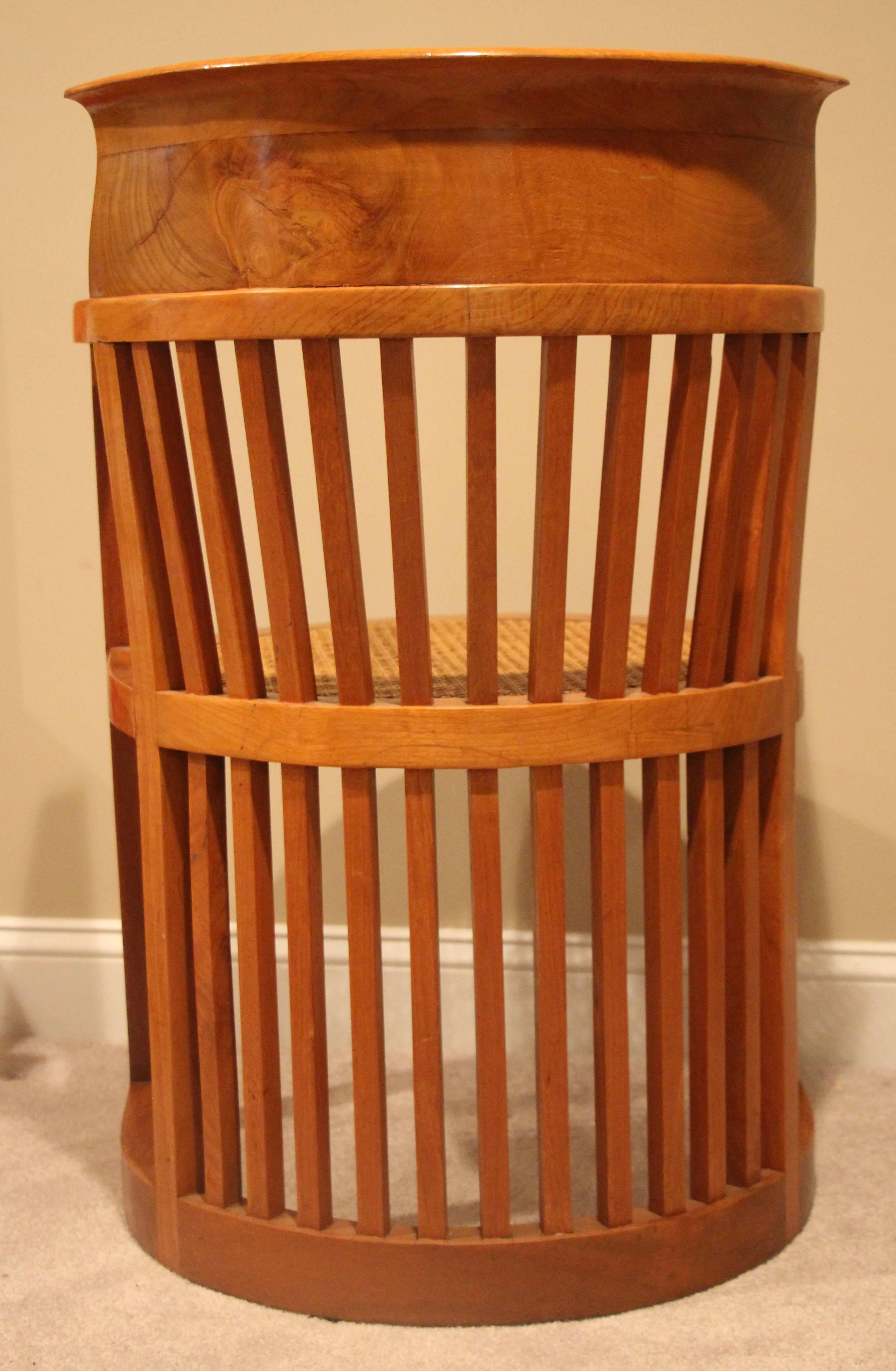 Pair of Frank Lloyd Wright style armchairs. Barrel back with square slats details, open arms. Elmwood, not marked. In good original condition, slight depression on one of the cane seats. Minor wood cracks in the back.