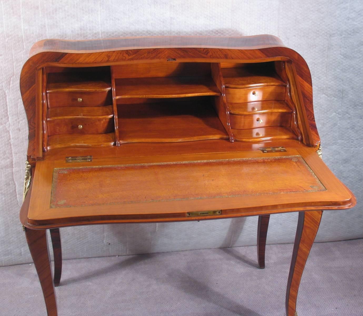 Exquisite French Louis XV style secrétaire with wave shaped front adorned with beautiful flower marquetry made of kingwood, rosewood and boxwood veneer, drop front writing desk with four interior drawers, two cubbie holes and one central shelf,
