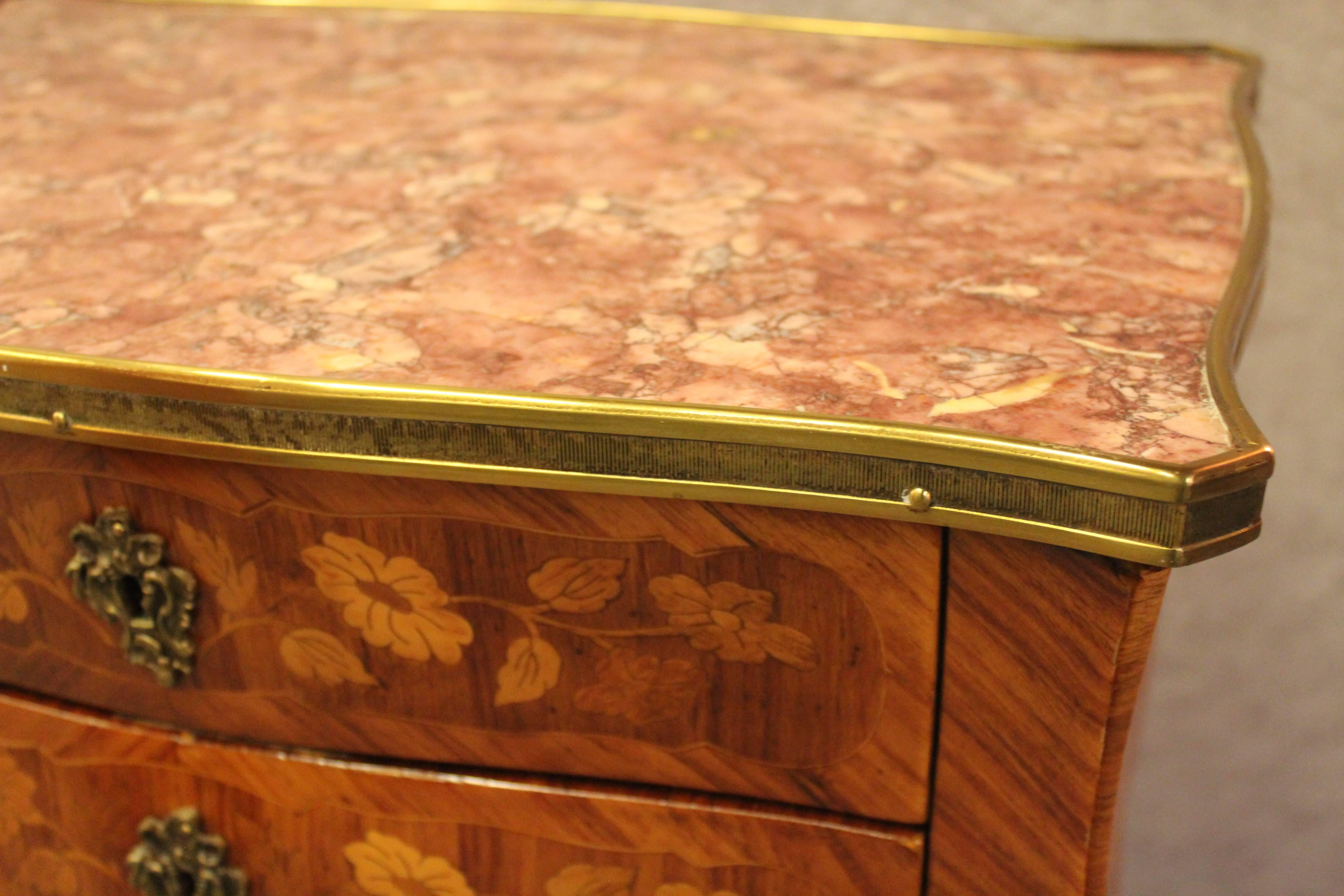 Exquise petite commode avec une élégante marqueterie de fleurs en bois de rose, bois royal et bois de satin. Trois tiroirs. Les côtés et le dos présentent un motif en placage de bois de rose réfléchissant. Avec plateau en marbre. Restauré par des