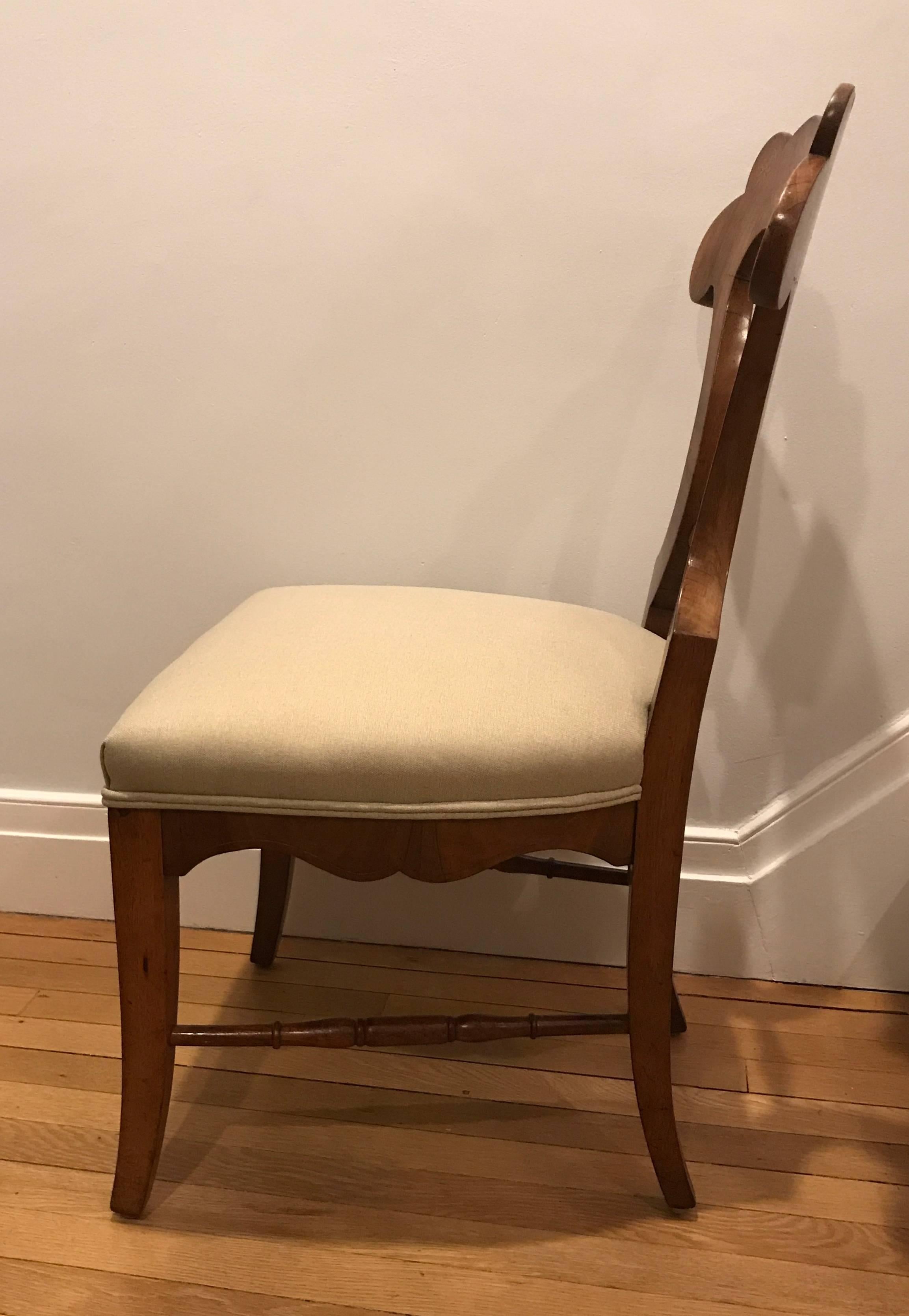 An exquisite set of six Biedermeier chairs made in Austria around 1810-20. The chairs are walnut veneered with floral elmwood inlays. The design of these chairs shows the influence of the famous Austrian Biedermeier furniture designer Josef