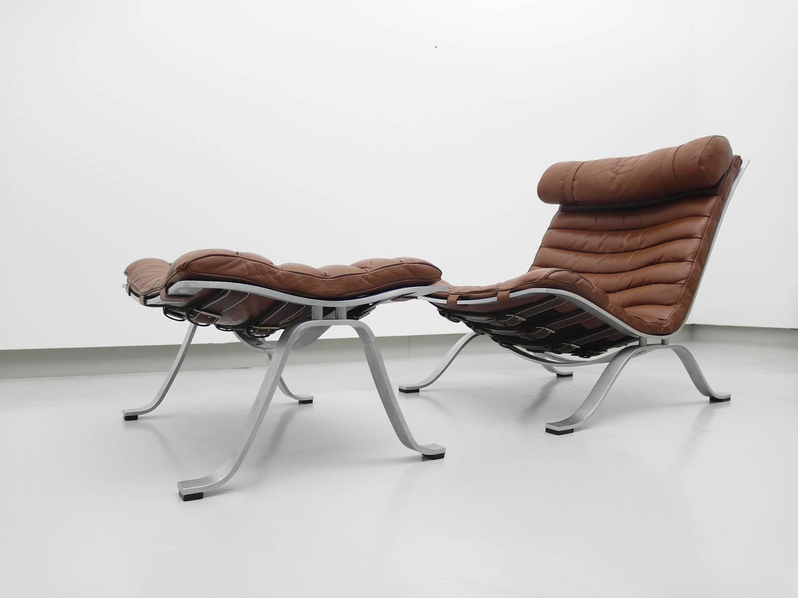 Comfortable lounge chair with ottoman designed by Arne Norell for Norell MöBel, Aneby, Sweden, 1966. 
This award winning lounge chair was made of high quality flat chrome-plated steel and has very thick original leather. 
The chair is in great