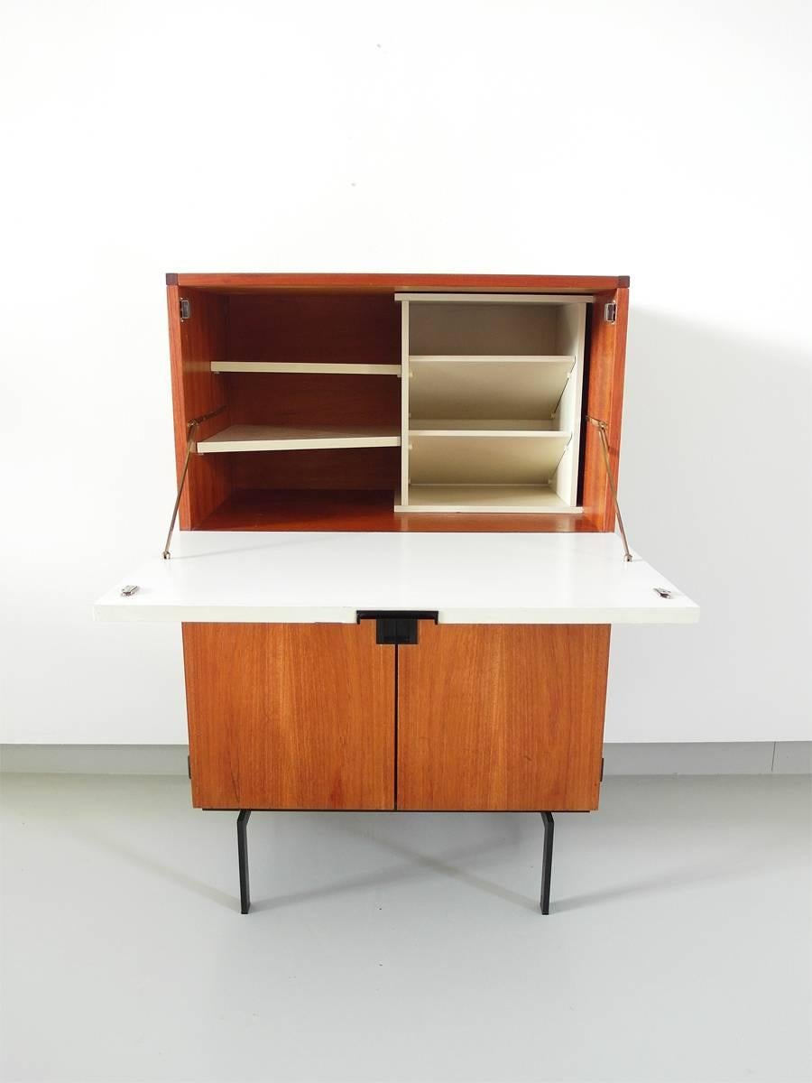 Small cabinet CU07 designed by Cees Braakman for UMS Pastoe in 1958. This elegant cabinet from the Japanese series features a white formica flap, which can be used as a desk top. On the inside a very nice white wooden interior designed to store