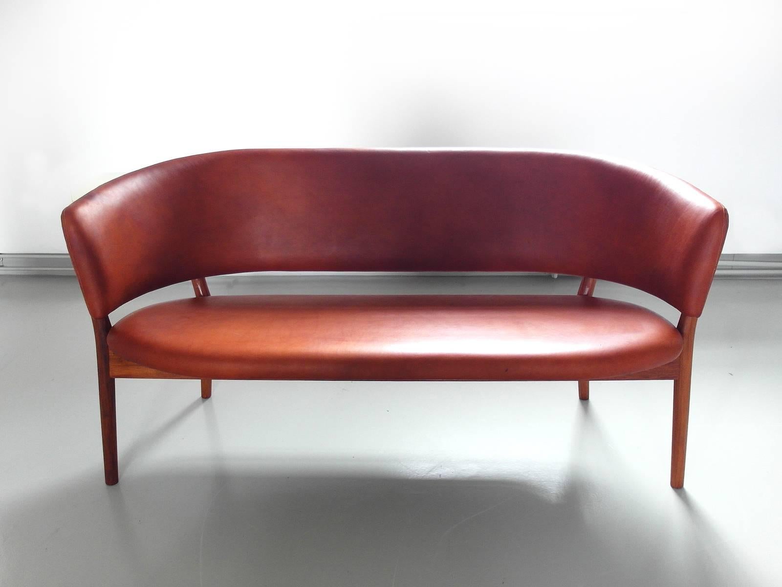 Beautiful and elegant shell sofa model ND82 designed by Nanna Ditzel in 1958, manufactured by Snedkergaarden, Denmark. The sofa is a classic Ditzel design. Circular in form, the arms and back are one piece which wraps around the sitter. The legs
