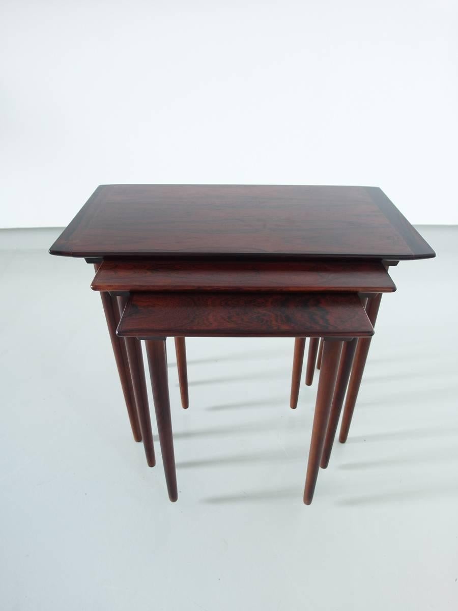 Elegant set of three rosewood nesting tables by Gustav Bahus, Norway, 1960s.
Well grained Brazilian rosewood nesting tables, the two smallest slide into a wood grove to secure them. The larger table size is 35 cm D x 63.5 cm W x 51 cm H the medium