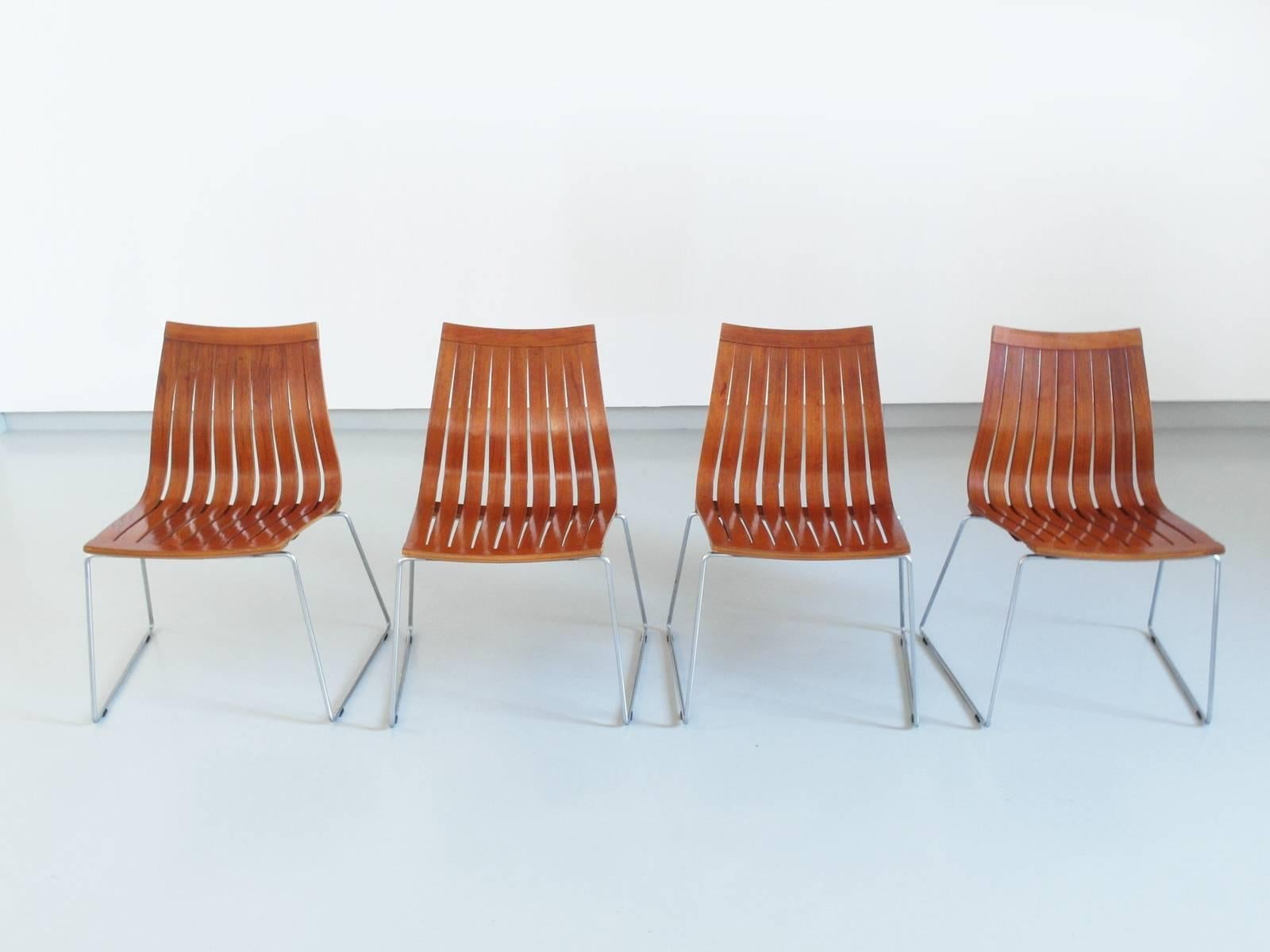 Rare set of four Tønnestav dining chairs designed by Kjell Richardsen for Tynes Møbelfabrikk, Norway 1960. This beautiful set of stackable dining chairs with continuous formed wood slats and chrome supports is made of teak veneered plywood slats.