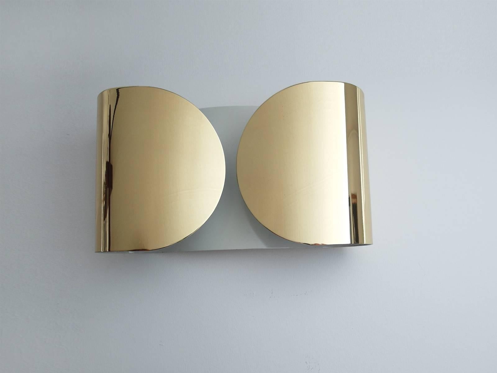 A sleek pair of gold polished Foglia wall lights designed by Tobia Scarpa for Flos, Italy 1966. These sculptural wall lights are composed of golden polished brass with white enamel on the inside. 
Although these lamps are still in production today,
