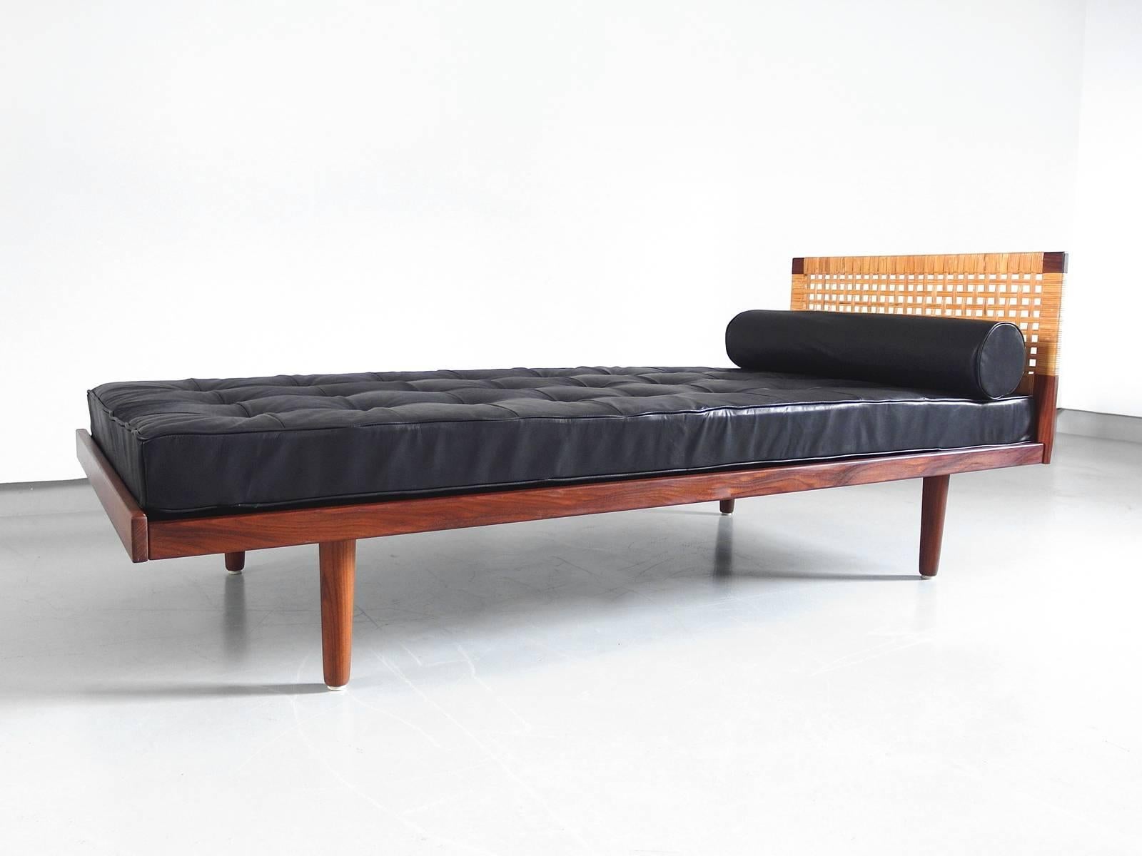 A teak daybed designed by Hans Wegner for GETAMA, Denmark, circa 1956. 
This teak wooden daybed shows a beautiful contrast in materials. Solid teak is used for the legs and frame. The cane headboard on one side is definitely a highlight to this