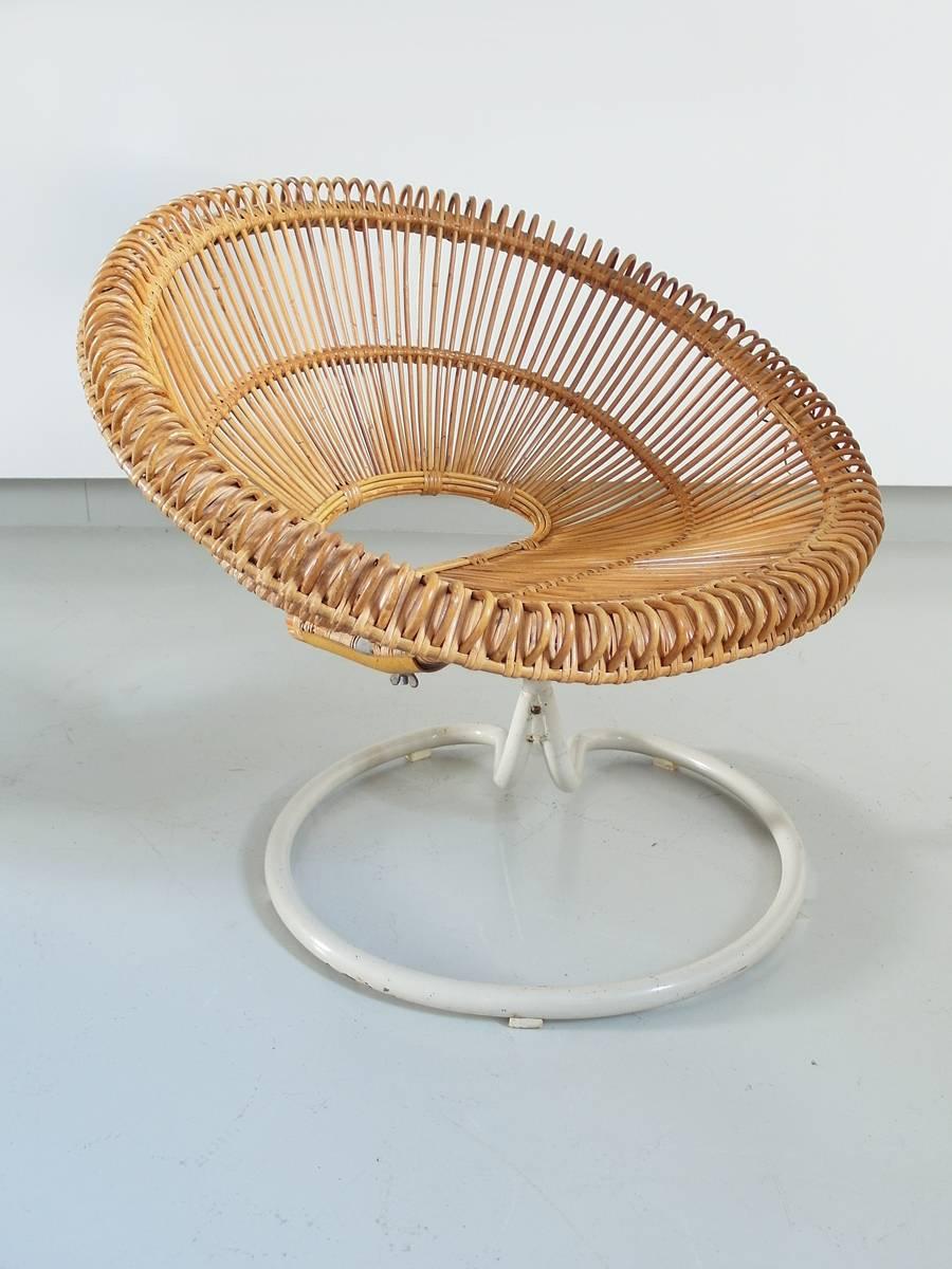 A stunning and rare rattan swivel chair by Janine Abraham and Dirk Jan Rol, France circa 1960s. The elegant basket seat shell is held by a very nicely curved swivel base in white metal. The rattan structure is very sturdy and the chair is