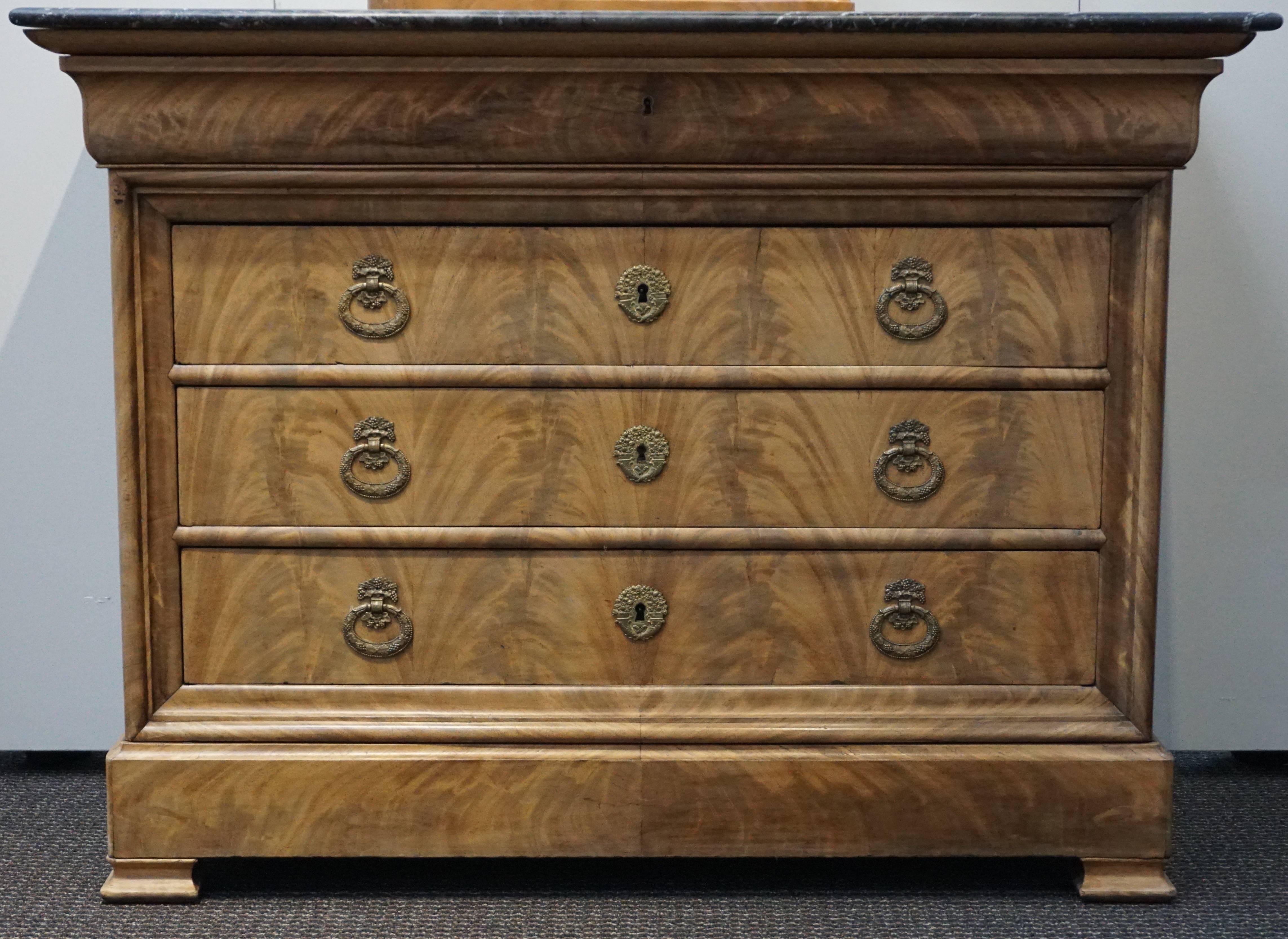 A Louis Philippe French mahogany and black marble chest with hidden drawer at the base, 19th century. Two keys to working locks included!

Dimensions: 37.25 H x 50.25 W x 22.25 D inches 
(94.6 x 127.6 x 56.5 cm)

Lower apron near feet extends