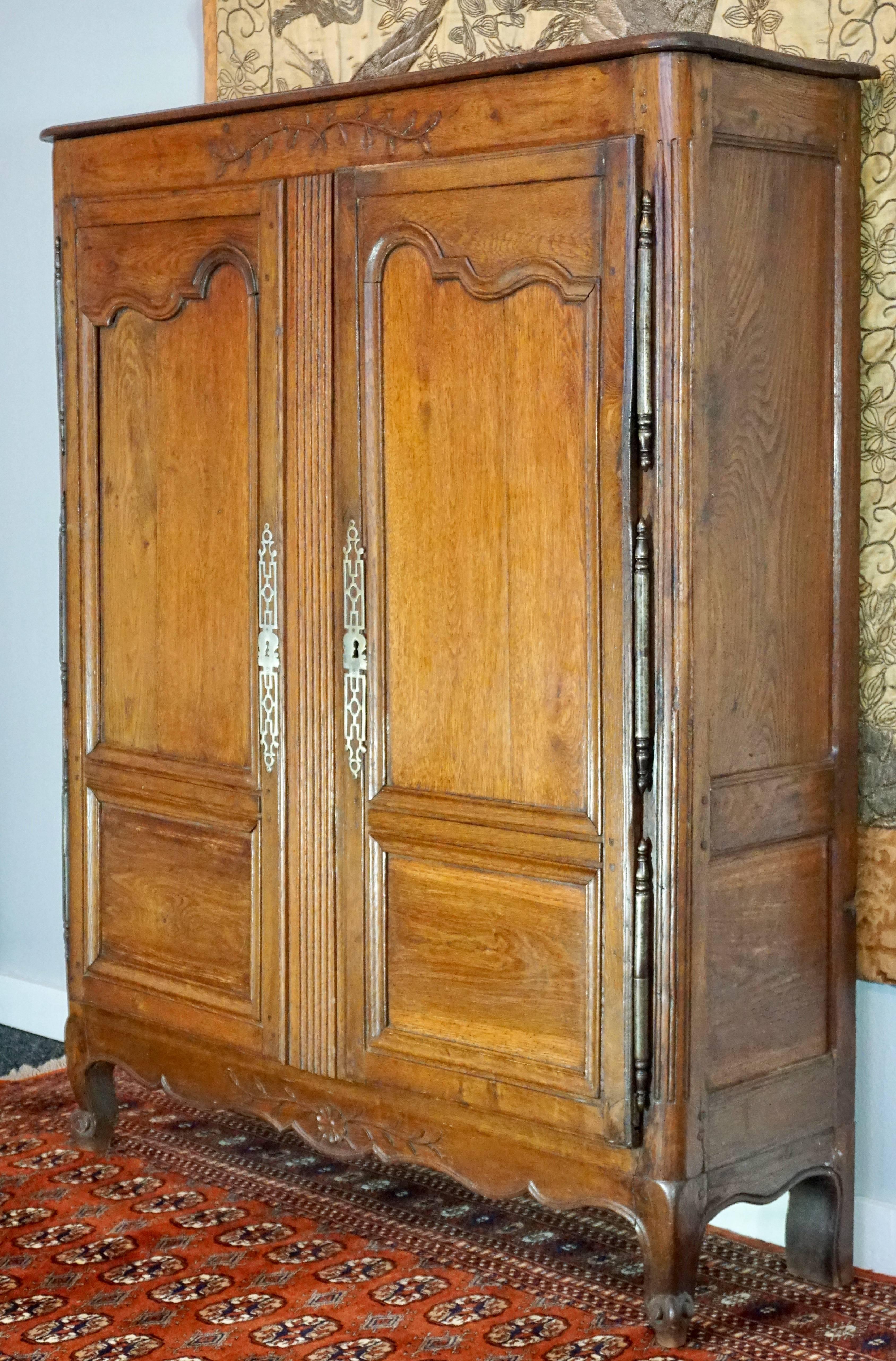 18th century Louis XV small pegged armoire from Provence, France, circa 1760. Beautiful patina and pegged construction walnut with hand chiselled carved flowers and wheat stalks. Hand-forged and hammered hinges and hardware with lock and key