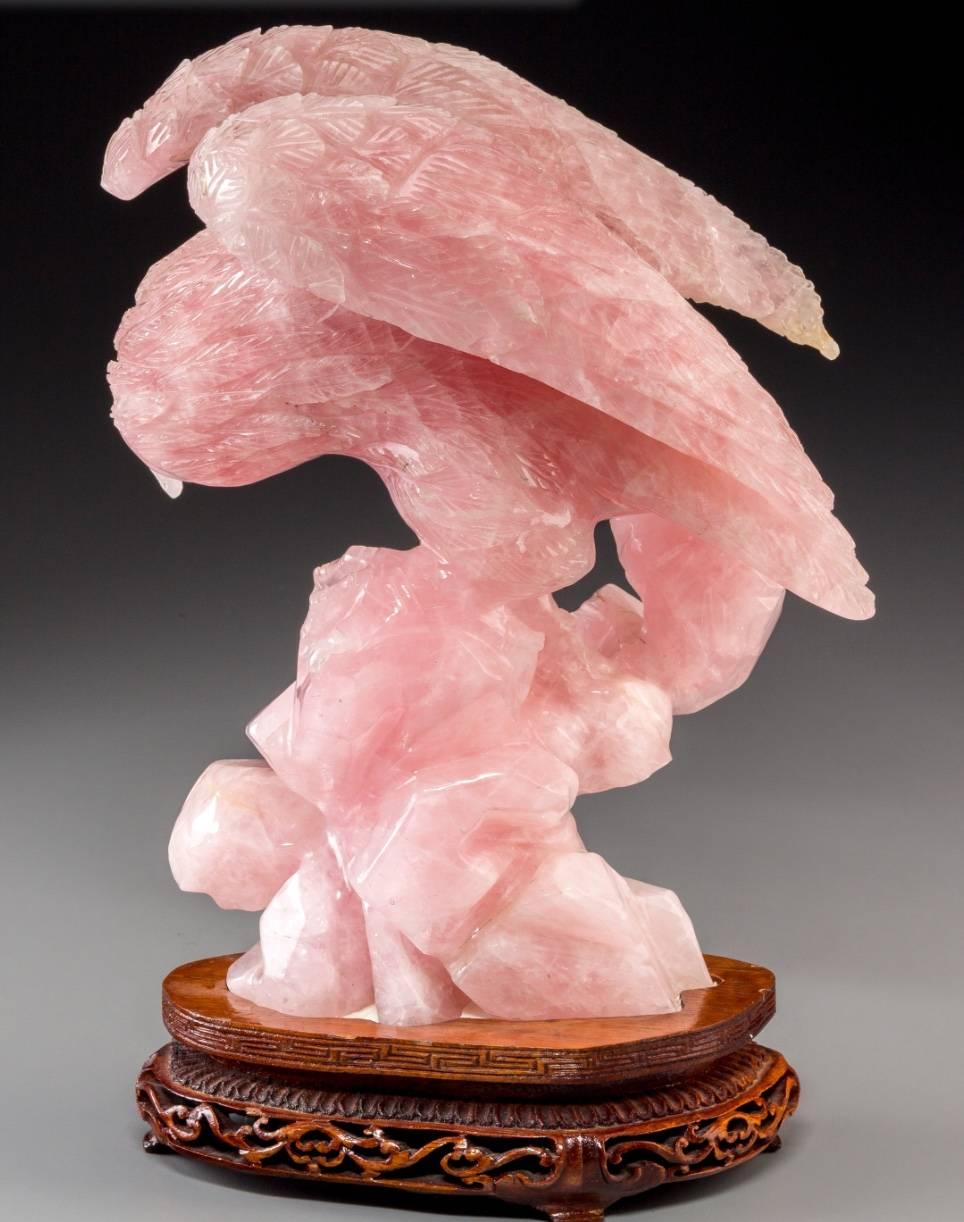 Chinese carved rose quartz eagle with carved rosewood stand, 20th century to mid century. The eagle is an asian symbol of strength and sharpness in character, Chinese and Japanese cultures revere the symbolism  and power the Eagle