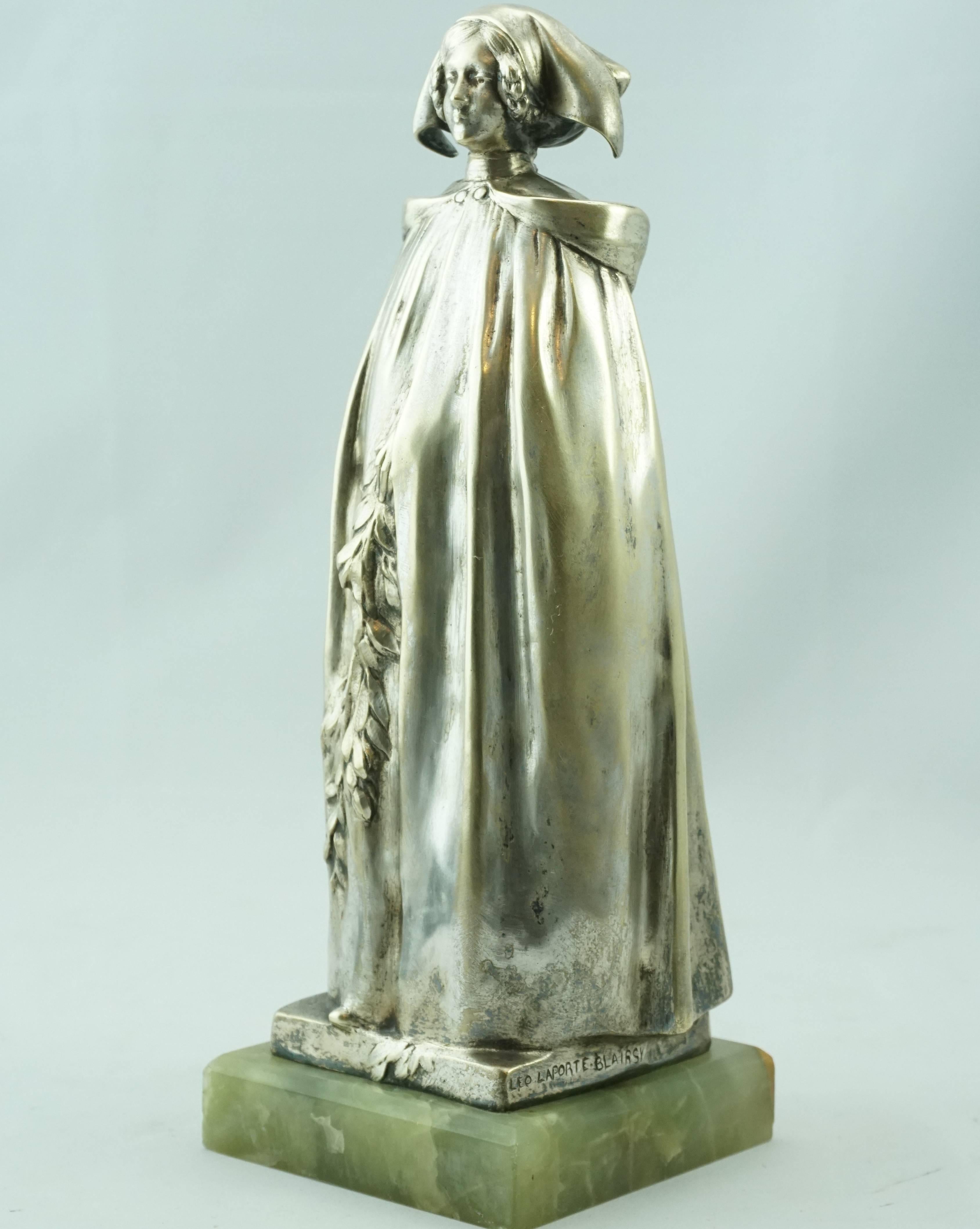 L'alsacienne Or Bretonne aux Rameau silver overlay patina by Leo Laporte Blairsy (French, 1867-1923). Depicting a woman in robe holding a garnet of flowers with a L'alsacienne or Bretonne bonnet hat. Bronze on original onyx stone base.

Measure: