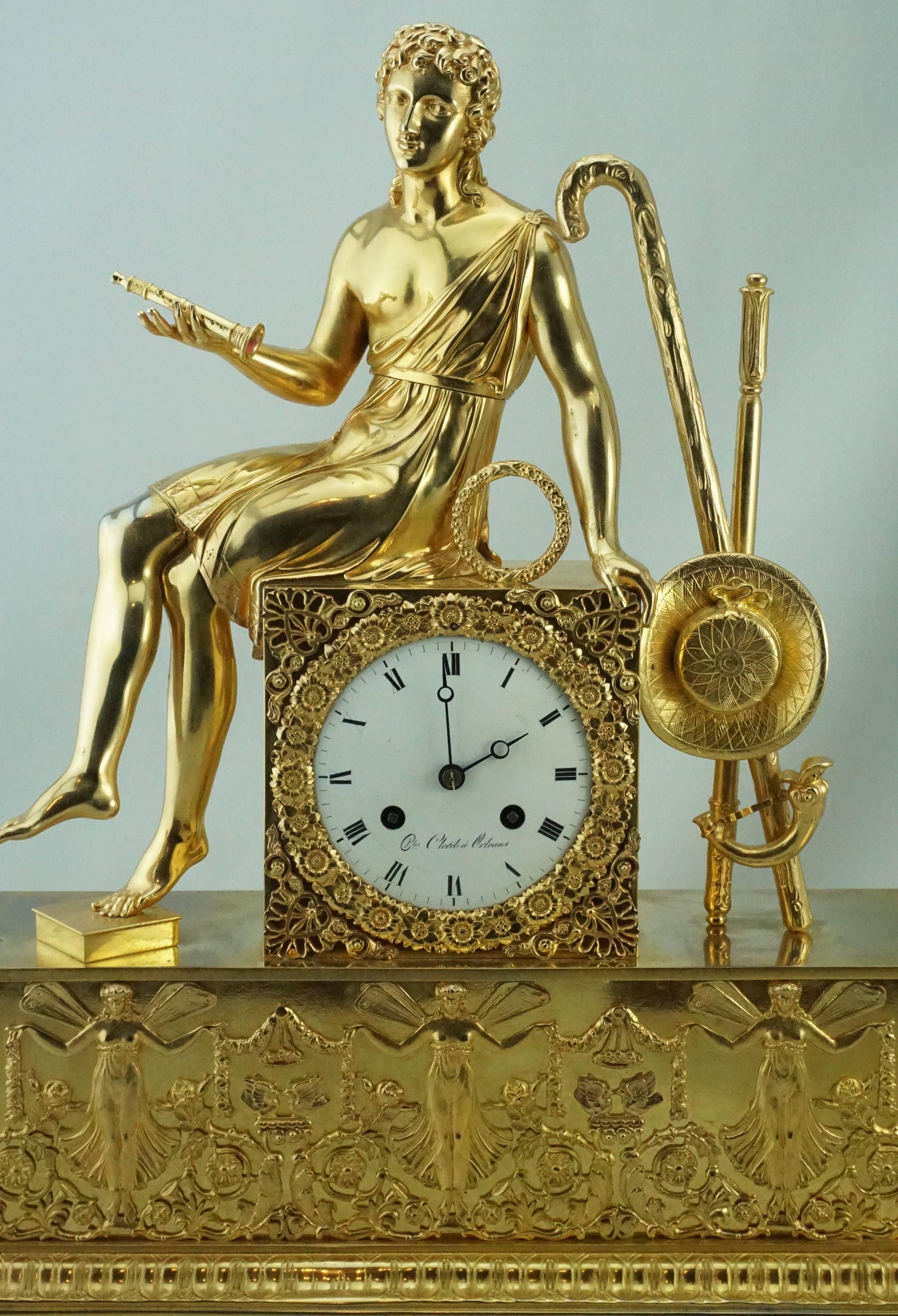 Early 19th century Empire gilt bronze mantel clock with allegorical scene depicting a young man sitting with a flute in his hand ready to play music. The musician is set above a raised case containing the dial. Very fine chiselling and gilt bronze