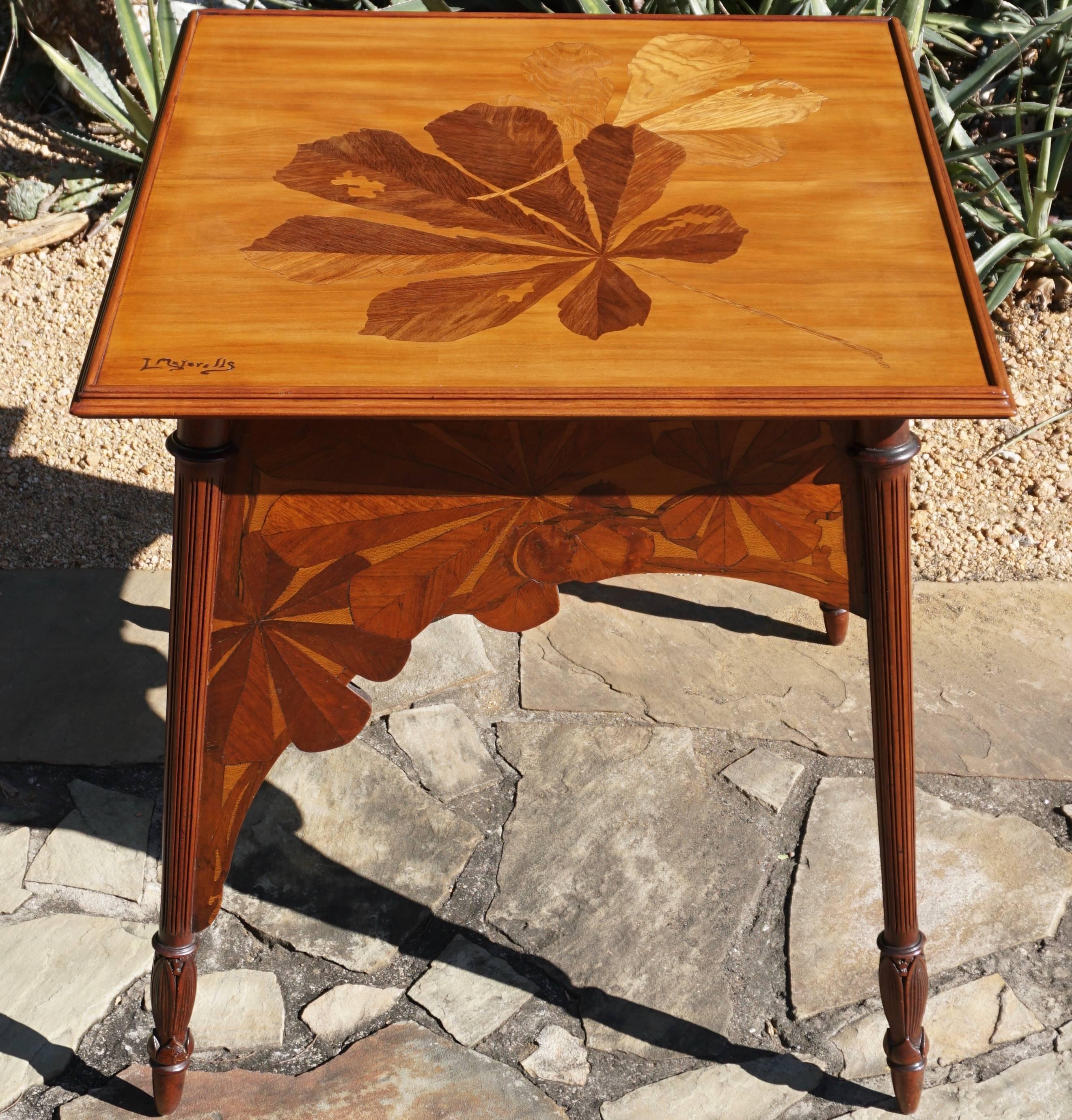 A French Art Nouveau marquetry walnut and exotic wood game table signed by Louis Majorelle. The tabletop is decorated with large leaves and stems. Stylized with fine marquetry side aprons support hand-carved legs, circa 1900. 

Similar table with