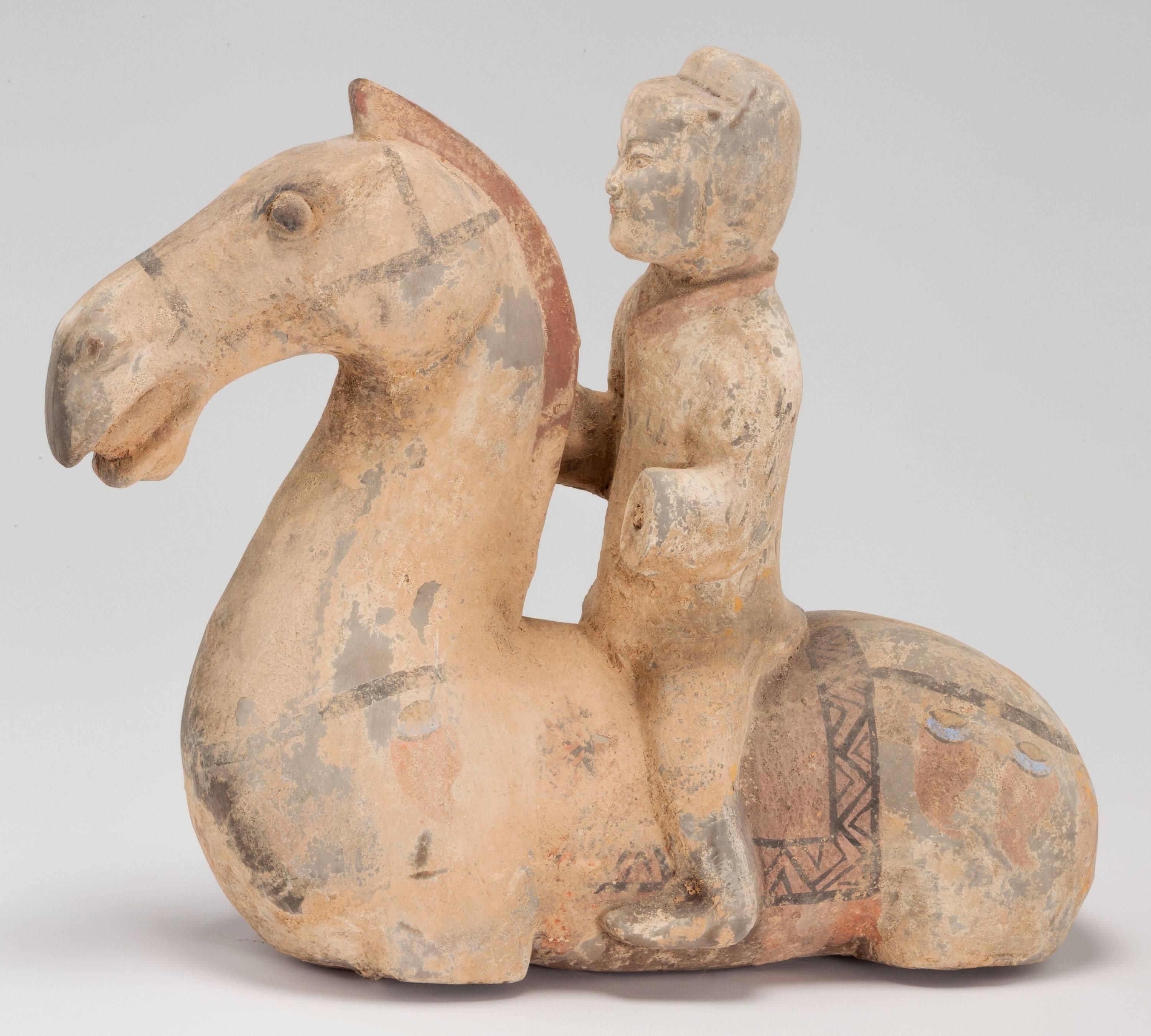 A Chinese Han unglazed earthenware horse and rider with traces of polychrome paint (probably more recent). Similar but more rare and beautiful to Tang artifacts; this statue will command attention and compliment any serious collection.