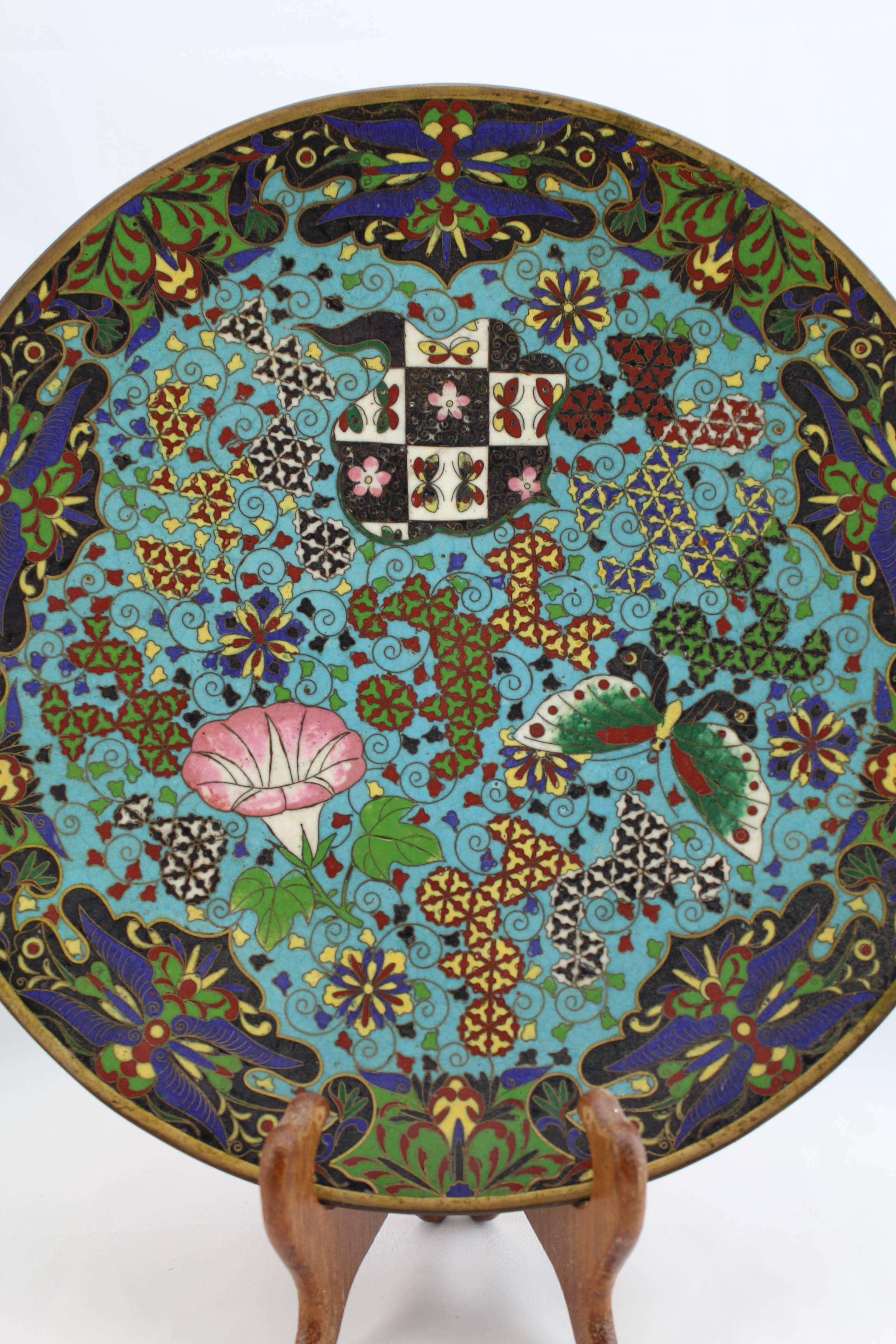 Japanese antique Meiji period cloisonné́ charger.
This cloisonné́ is intricate and masterfully executed representing three scenes. One scene is of a checkered black and white stingray with butterflies and flowers. The second scene depicts pink