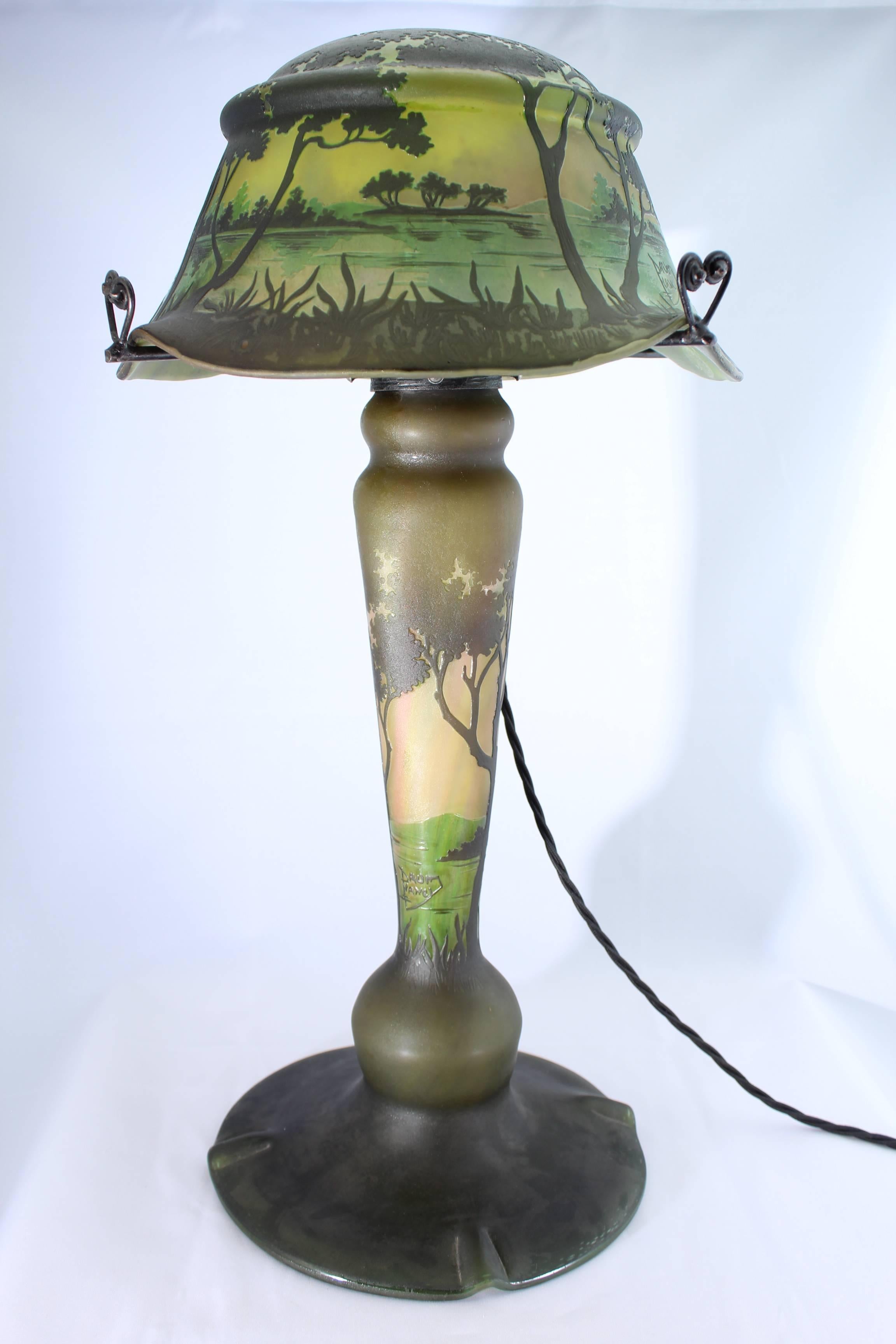 Large and decorative Art Nouveau mushroom lamp by Daum Freres of Nancy, circa 1900. This lamp 20 years ago would have went for $60,000. Rare and important. Land scape in greens, browns, creams and yellows acid etched and carved. Two light fixture