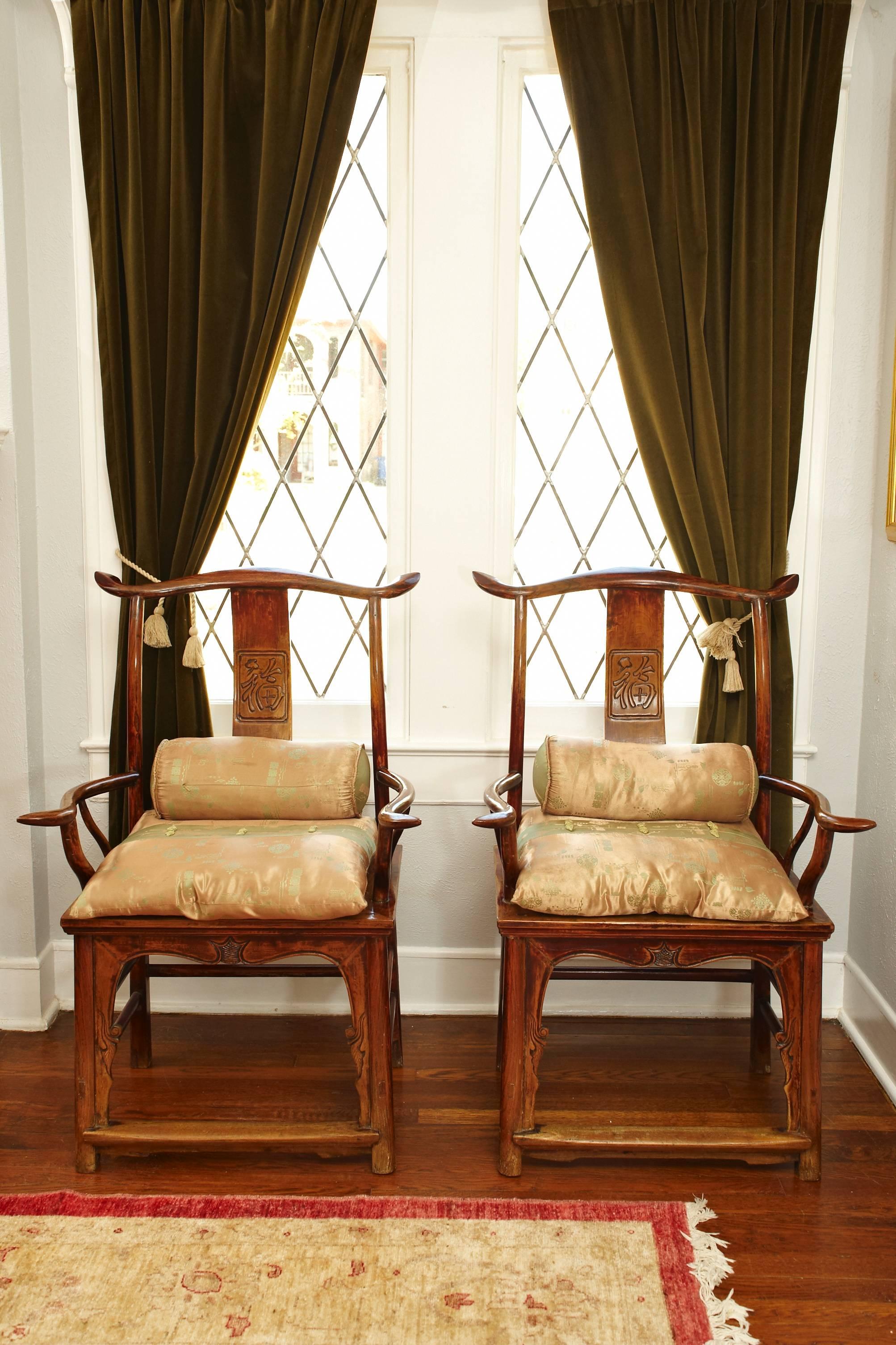 Late 18th-19th century elmwood armchairs, Ming style.

Each has a curved crest rail supported on curved rear posts and an S-shaped back splat. The arm rails are supported on slender standing stiles and extend beyond the front posts. The rectangular