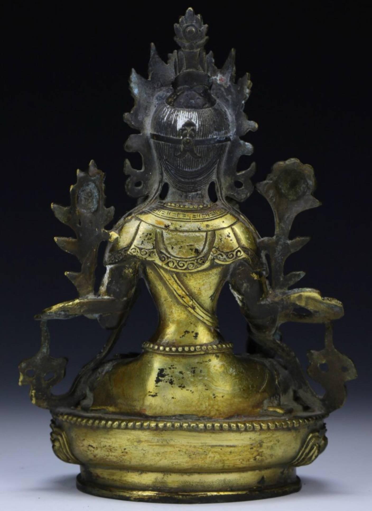A gilt Tibetan bronze Buddha or Tara, seated with on hand raised and the other holding a sceptre. Original sealed base with rattling contents and Ming Yin/Yang symbol seal. Qing Dynasty.

Height: 8.5 Inches
Width: 6 Inches

Condition: Some loss to