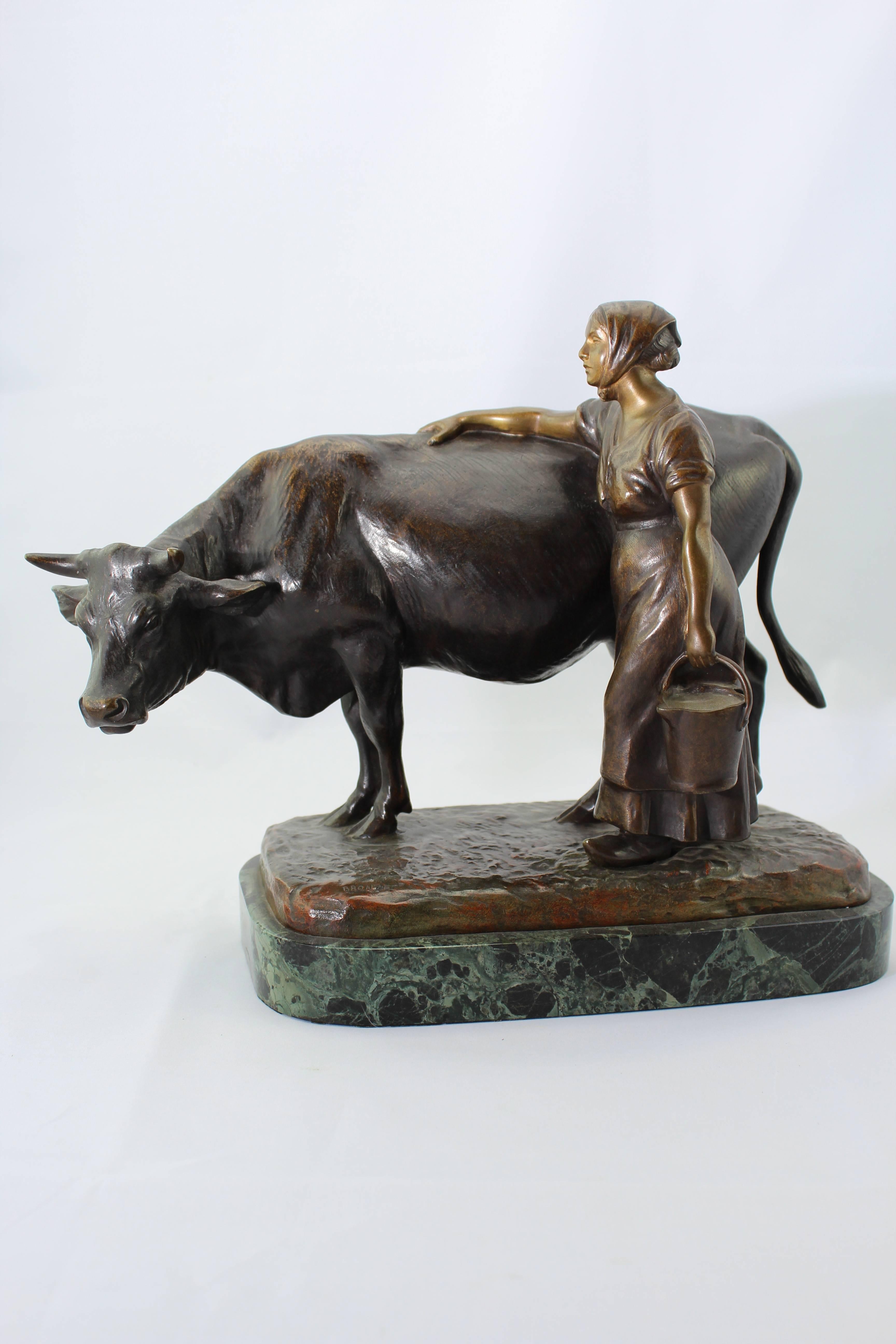 Louis Riche (French, 1877-1949) Paris.

An early Art Nouveau 20th century, French, bronze animalier of a large standing cow and a pensive milk maiden who just finished doing one of her chores carrying a full bucket of milk resting her tired figure
