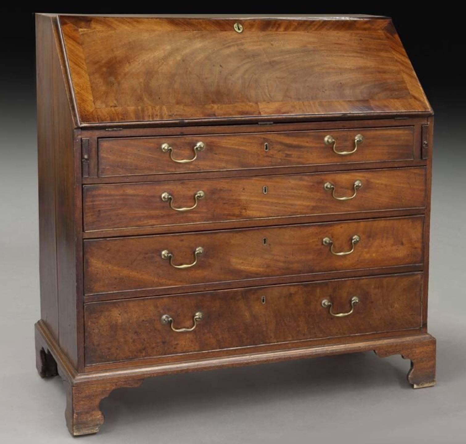 Georgian mahogany drop front secretary bureau desk, the crossbanded lid revealing a nicely fitted interior over four graduated full width drawers with original brass pulls and iron locks, standing on shaped bracket feet. 

Measures: 43.5
