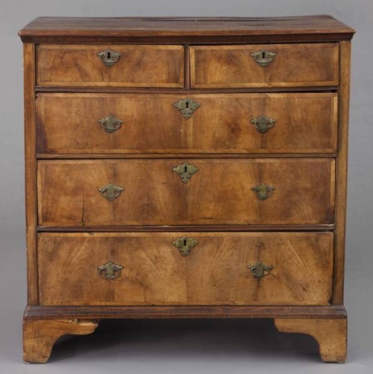 Early Georgian mixed wood five-drawer chest, with faded mahogany crossbanded drawer fronts with early (possibly original) engraved brass cotter pin backed pulls and standing on bracket feet. Commode.
Measures:
39