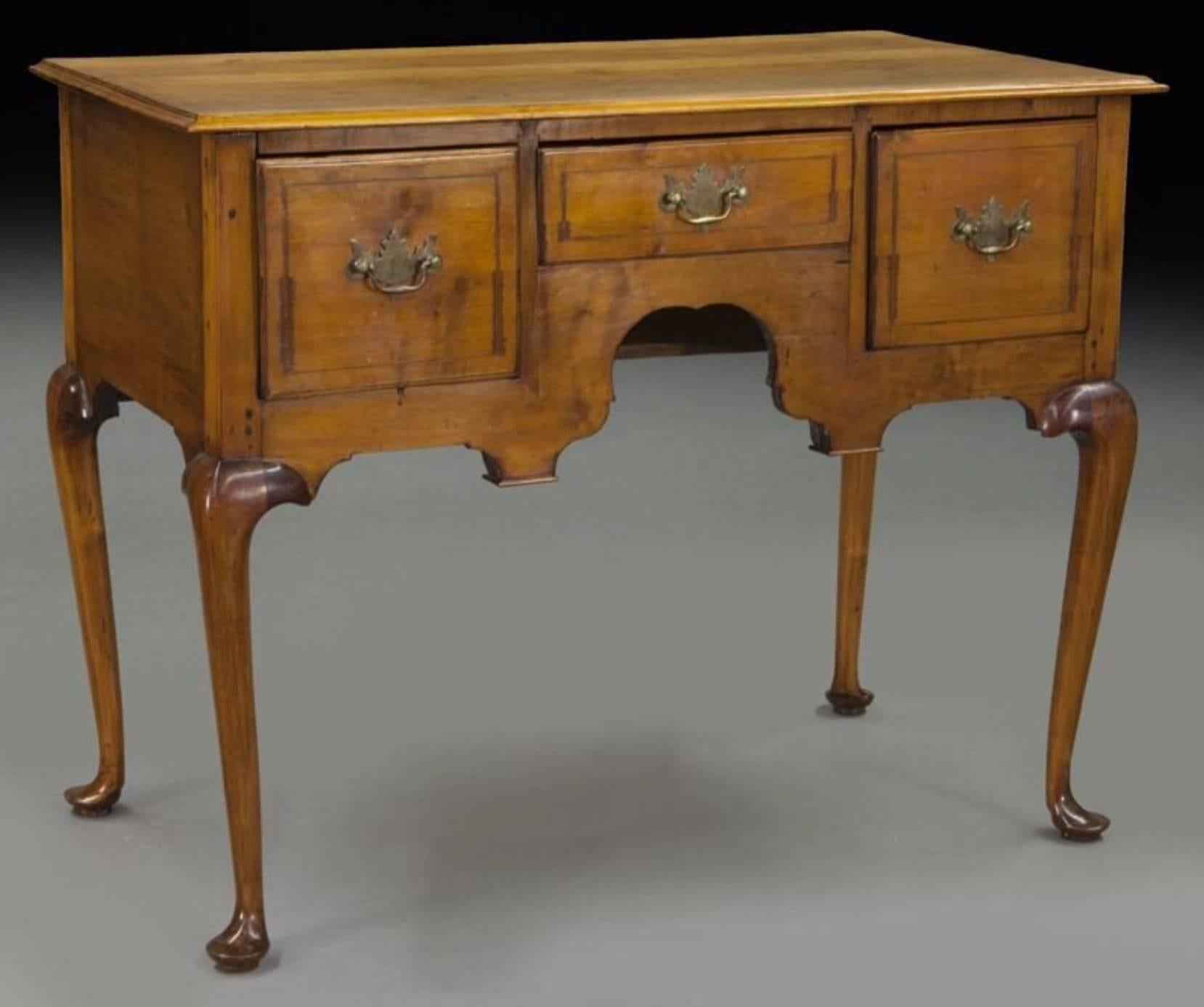 
American 18th century maple dressing table with overhanging rectangular top, over three drawers with shaped apron and standing on tall Queen Anne style legs. Living room, hall and bedroom table.

Measures: 31.5