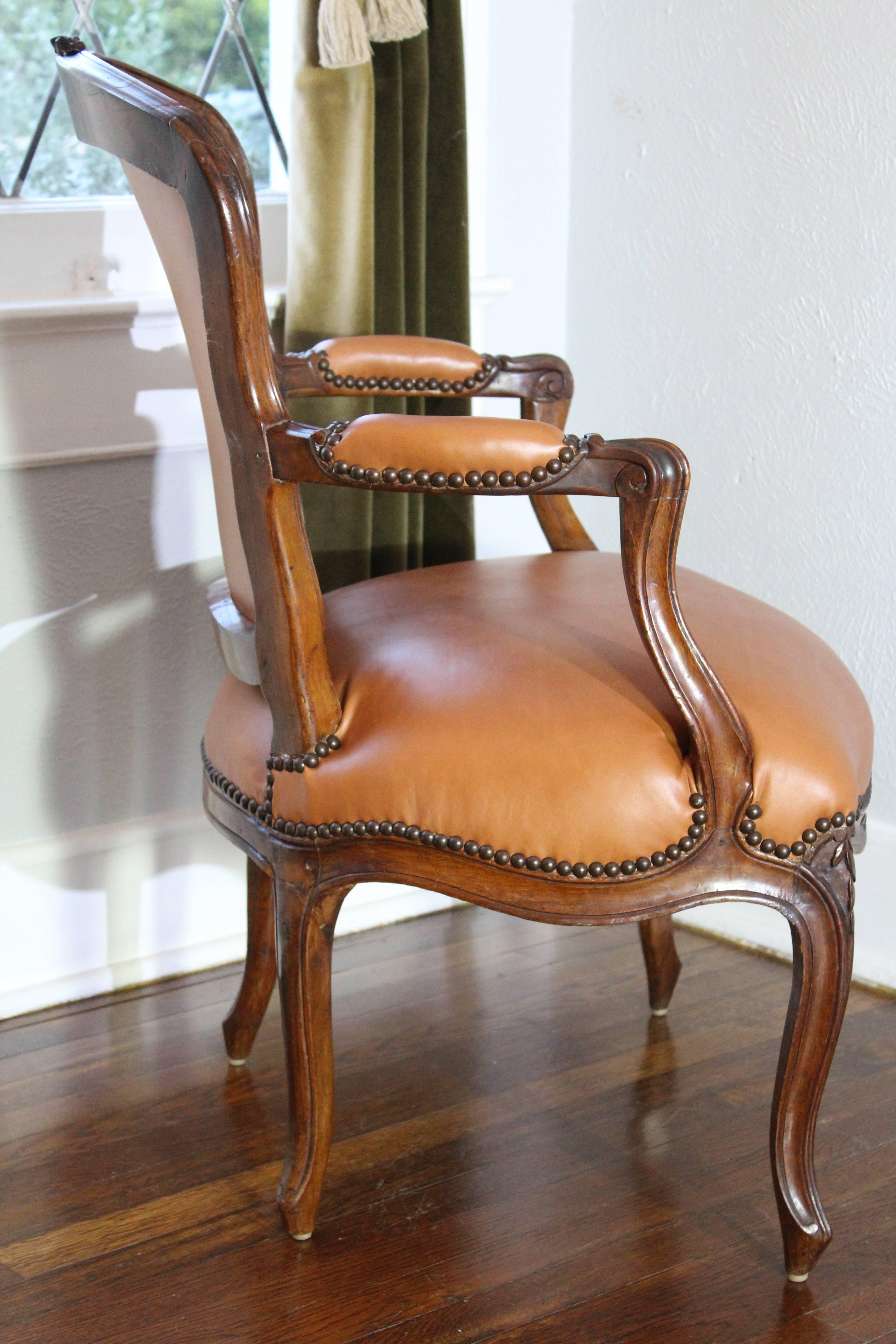 A Louis XV period fauteuil armchair. Mid-18th century walnut open armchair with cabriole legs and shaped front rail, The shaped back gently inclined over generous seats. Upholstered in a new rich brown Italian leather. Very sturdy and ready for