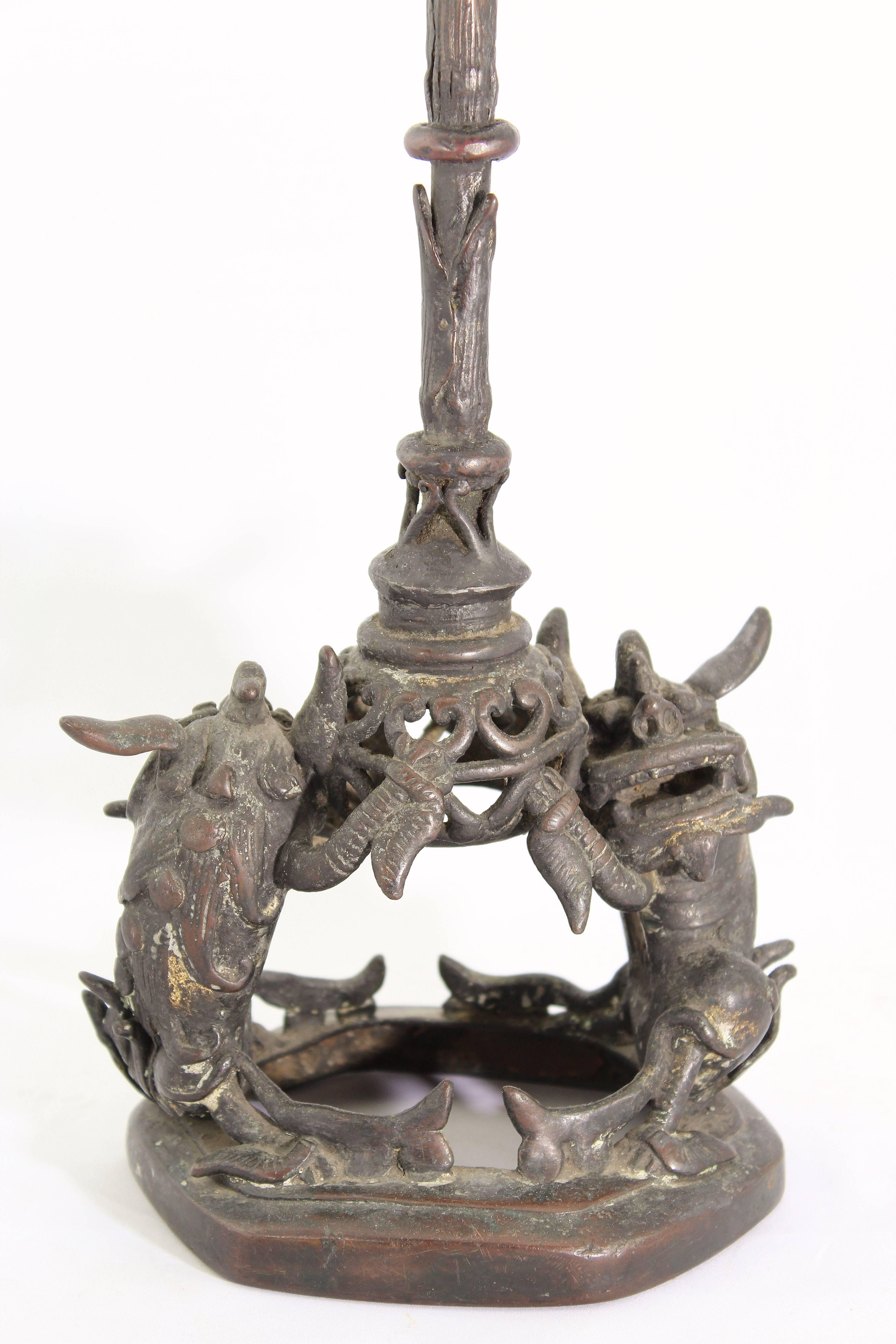 Ming period temple bronze candle pricket, circa 16th Century.

Whimsical dragon food dogs holding a bamboo candleholder.

Measures: Height 20 inches,
width 6 inches.

Excellent condition.