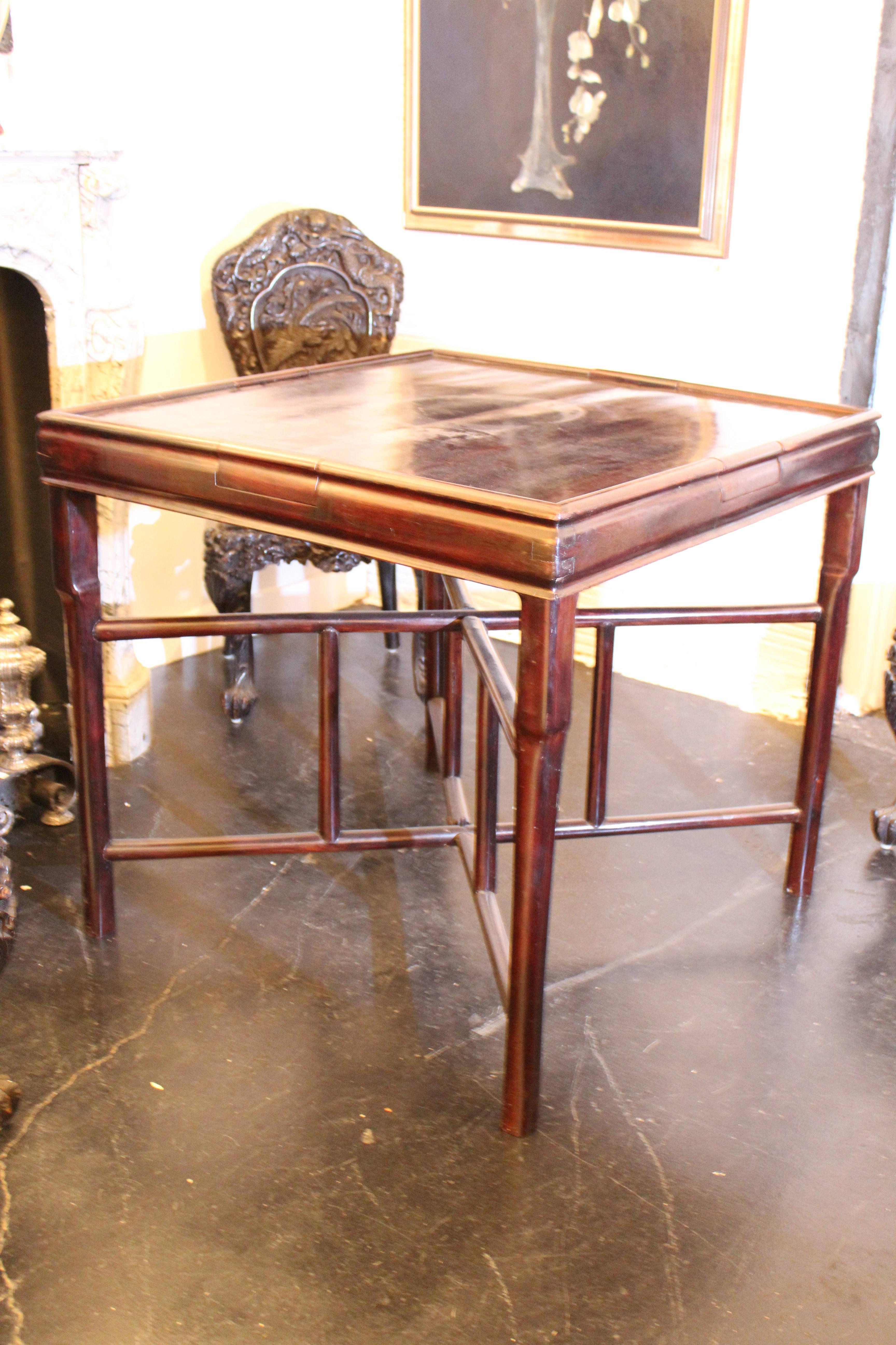 A Chinese hardwood games table. The wood may be zitan wood but I am not an expert. This dark hardwood table comes apart in two pieces (the top and the legs) which fold for easy transportation. Very sturdy and ready for a game of cards, checkers,