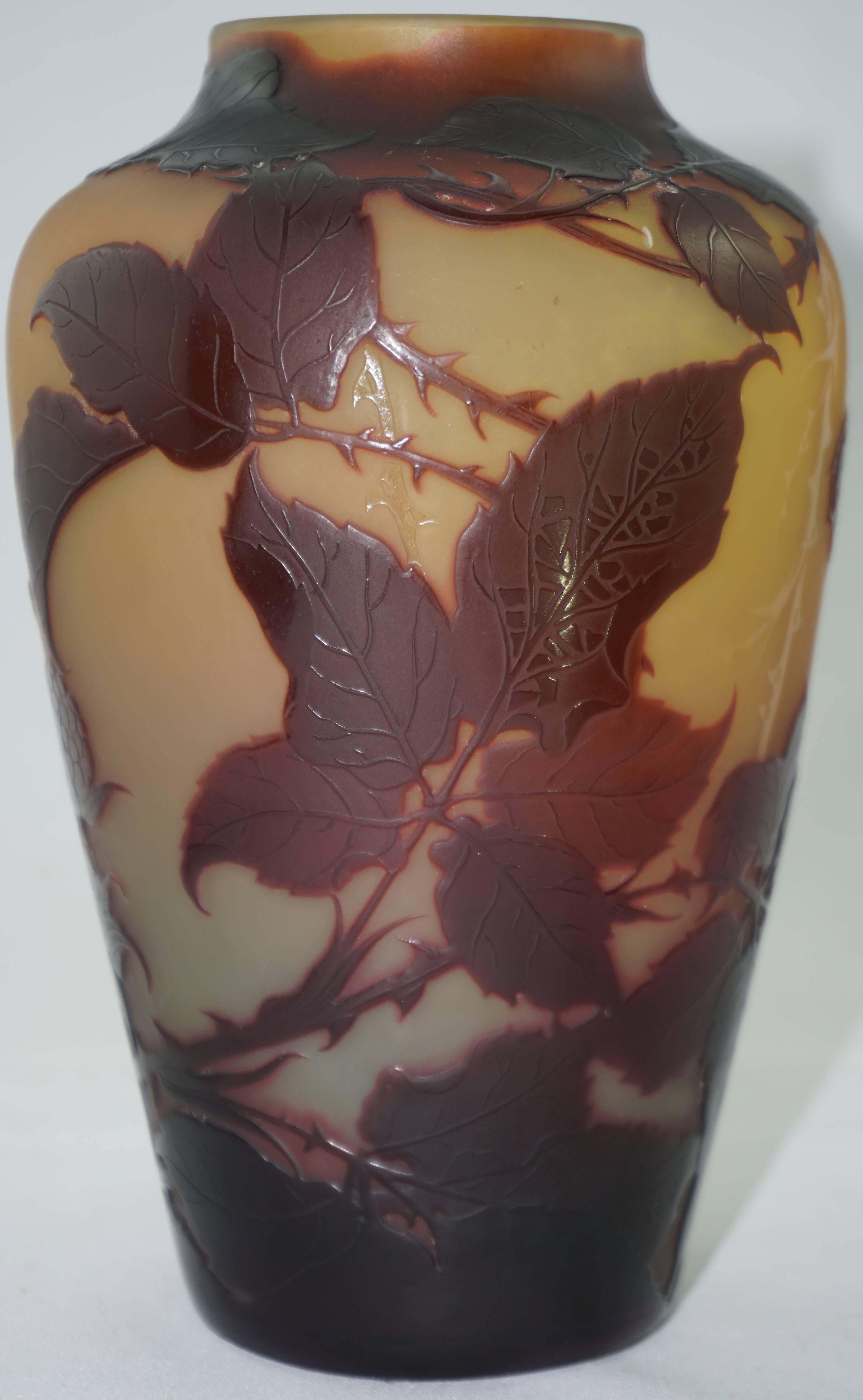 This art nouveau Paul Nicolas D'Argental vase is rare in that it is double decorated with Leaves and a butterfly under the overlay of beautifully carved flower seed pods and foliage. Orange, yellow browns and pink make up this delightful collectors
