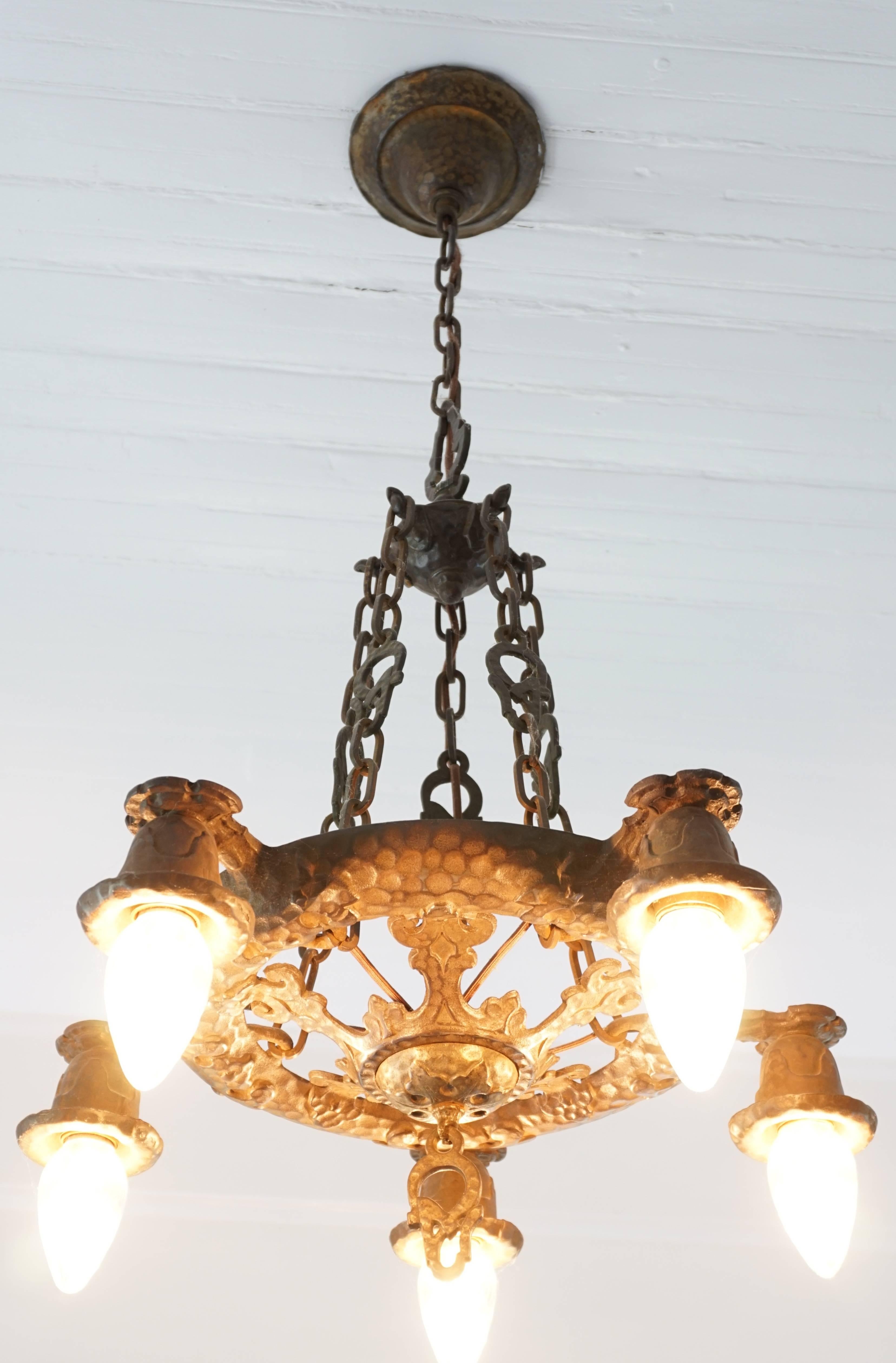 Arts & Crafts wrought cast iron hammered chandelier, circa 1900. From England or possibly American. Beautiful condition with a chocolate brown patina and hidden goals undertones. Five-light Chandelier lighting fixture.

Measures: Height 35