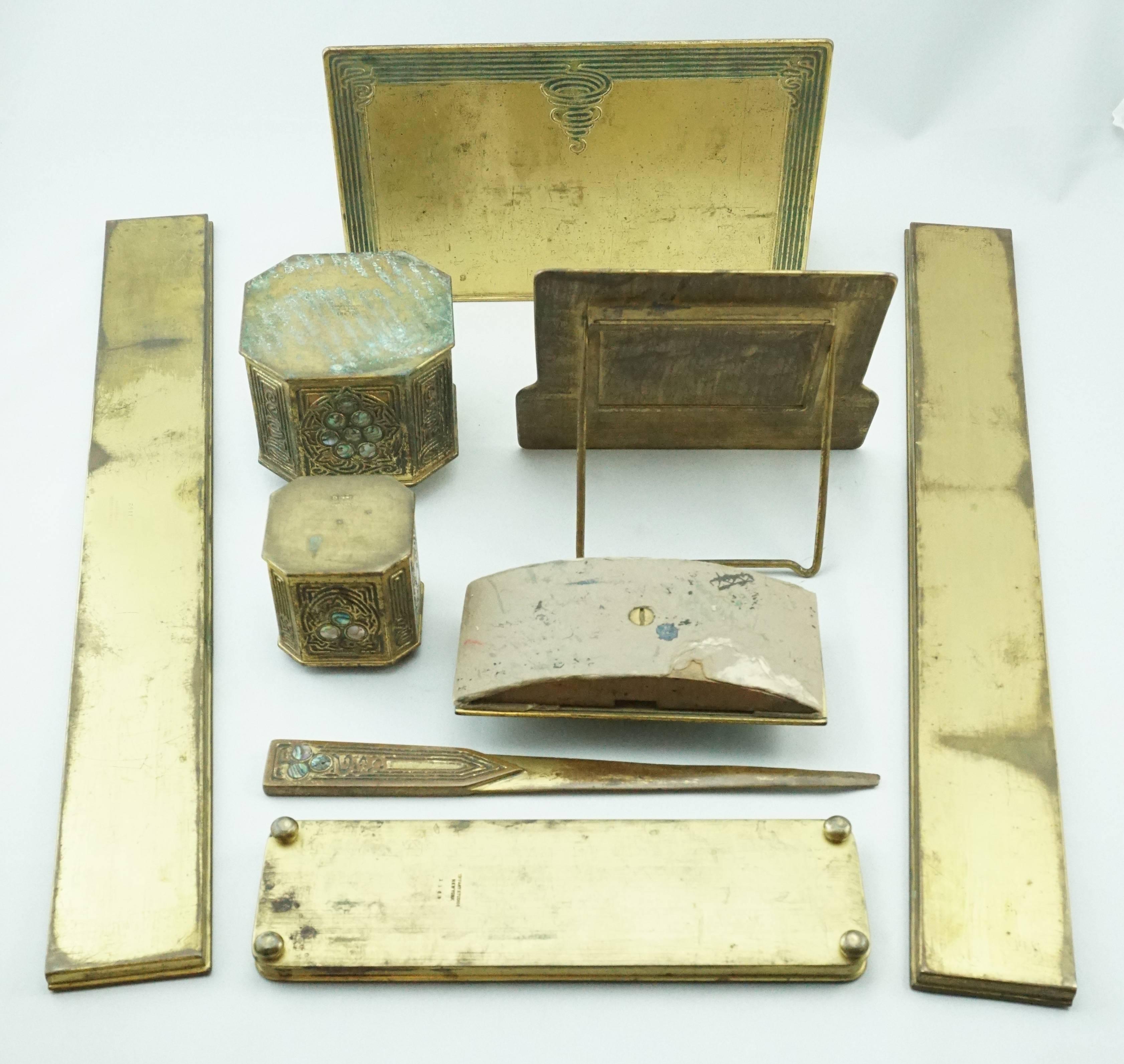 Tiffany Studios New York abalone nine-piece bronze desk set, circa 1910. 

Tiffany Studios
A nine-piece desk set in the abalone pattern, circa 1910.
Gilt bronze with mother-of-pearl from abalone
comprising rocker blotter, easel calendar,
