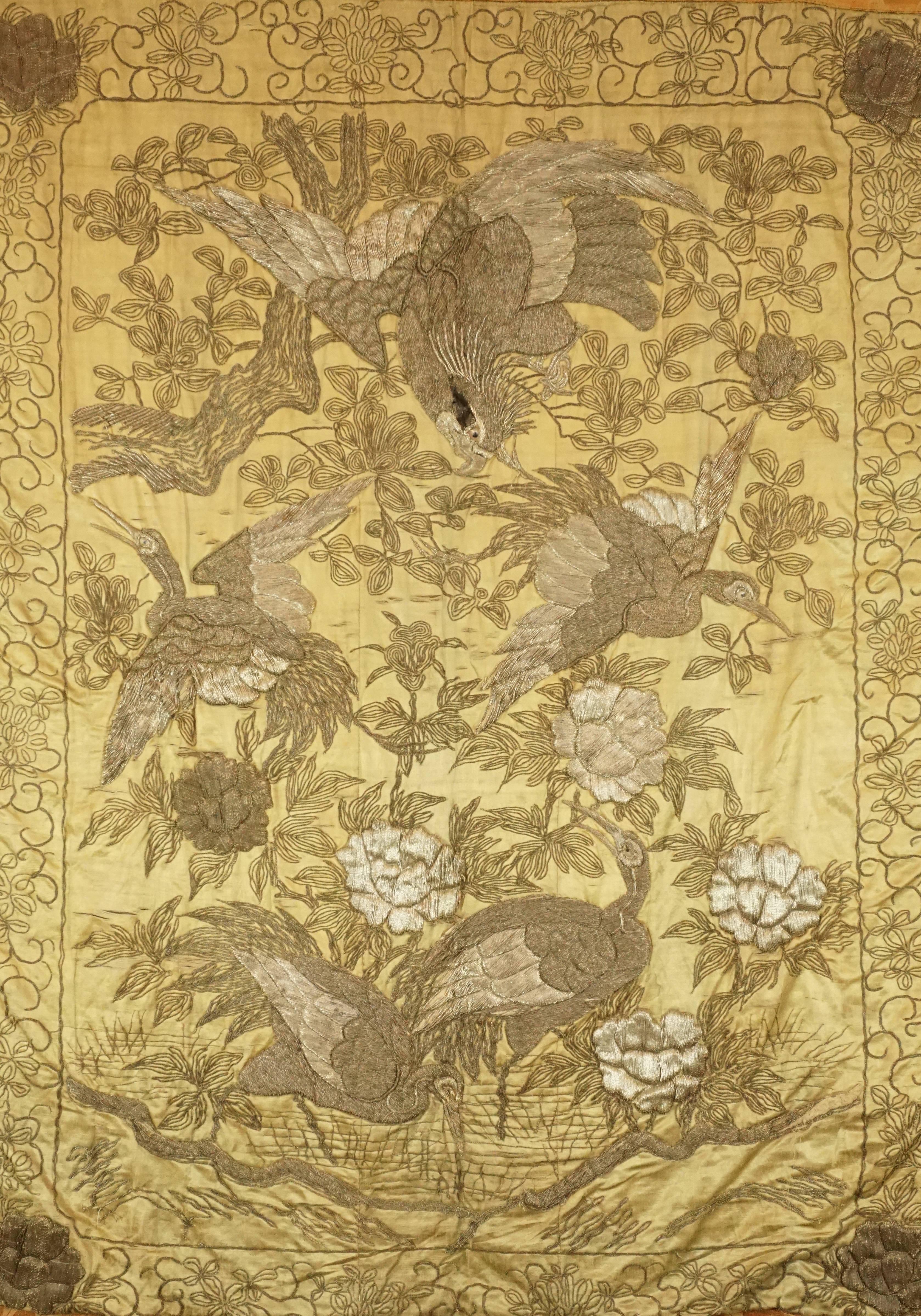 Japanese Meiji Period Silver Embroidery On Silk Of Hawk Attacking White Cranes. Ca. 1885 . Entwined silver threading and other yarns and are meticulously embroidered with texture and depth on gold colored silk to create a majestic and dramatic scene