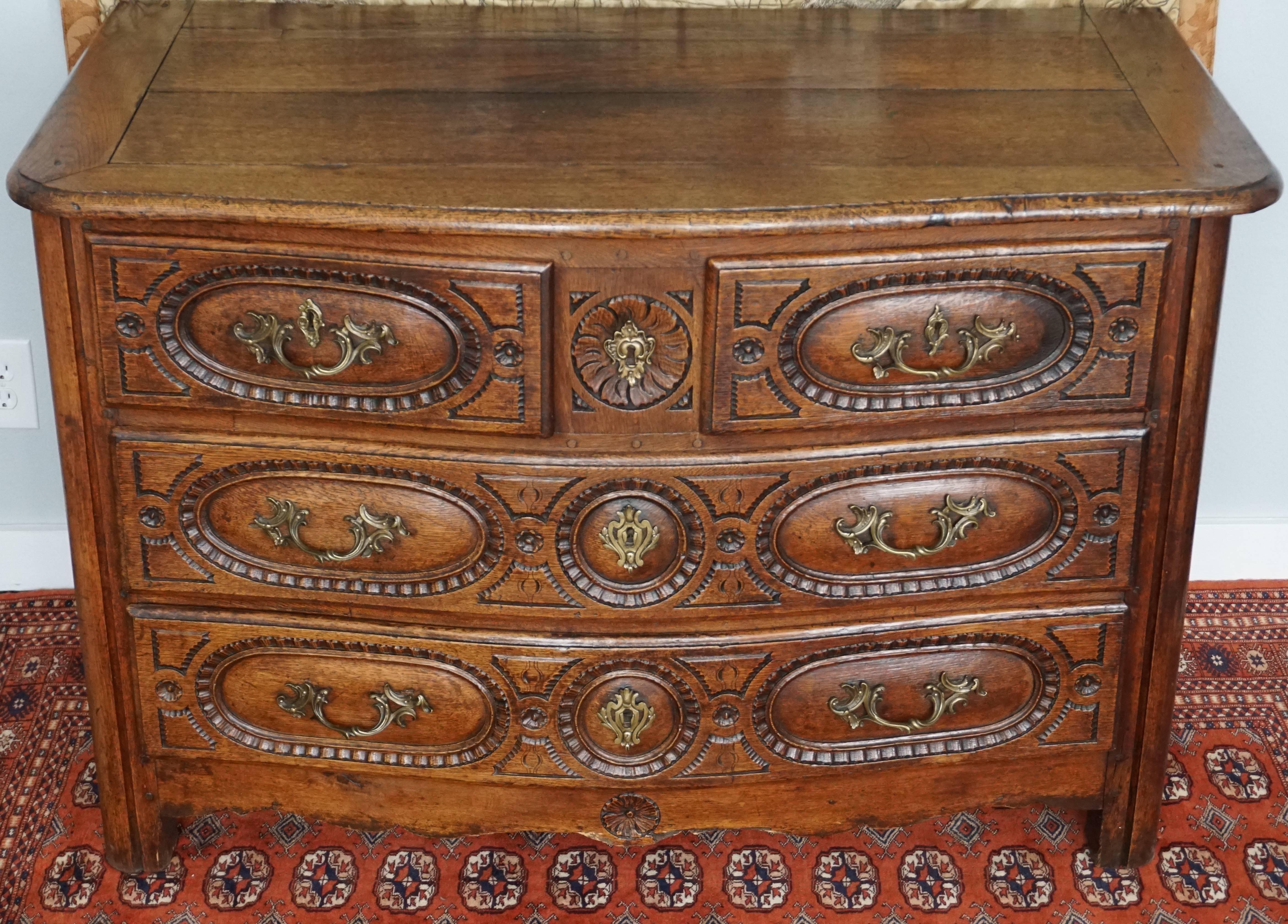 Louis XIV-XV French 18th century commode chest, 18th century, French Provincial oak four-drawer commode with bow serpentine front and carved drawer fronts.

Measure: 31.5