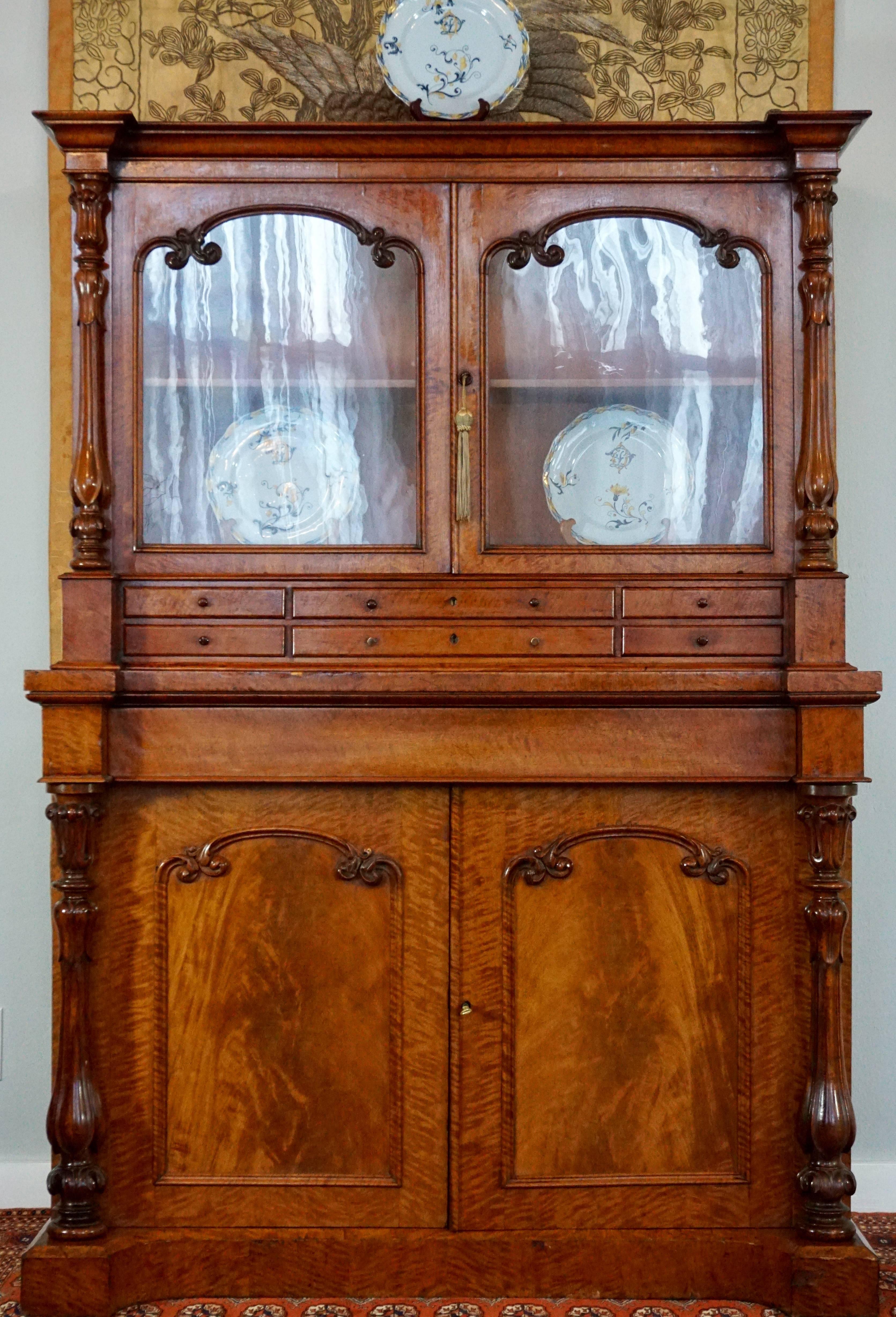 English Victorian flame mahogany bookcase, with fine carvings and good patina, and original wavy glass doors, two keys included.

circa 1870, 

Very good condition with wear commensurate of age and use!

Measures: Height 70 inches
Width 48