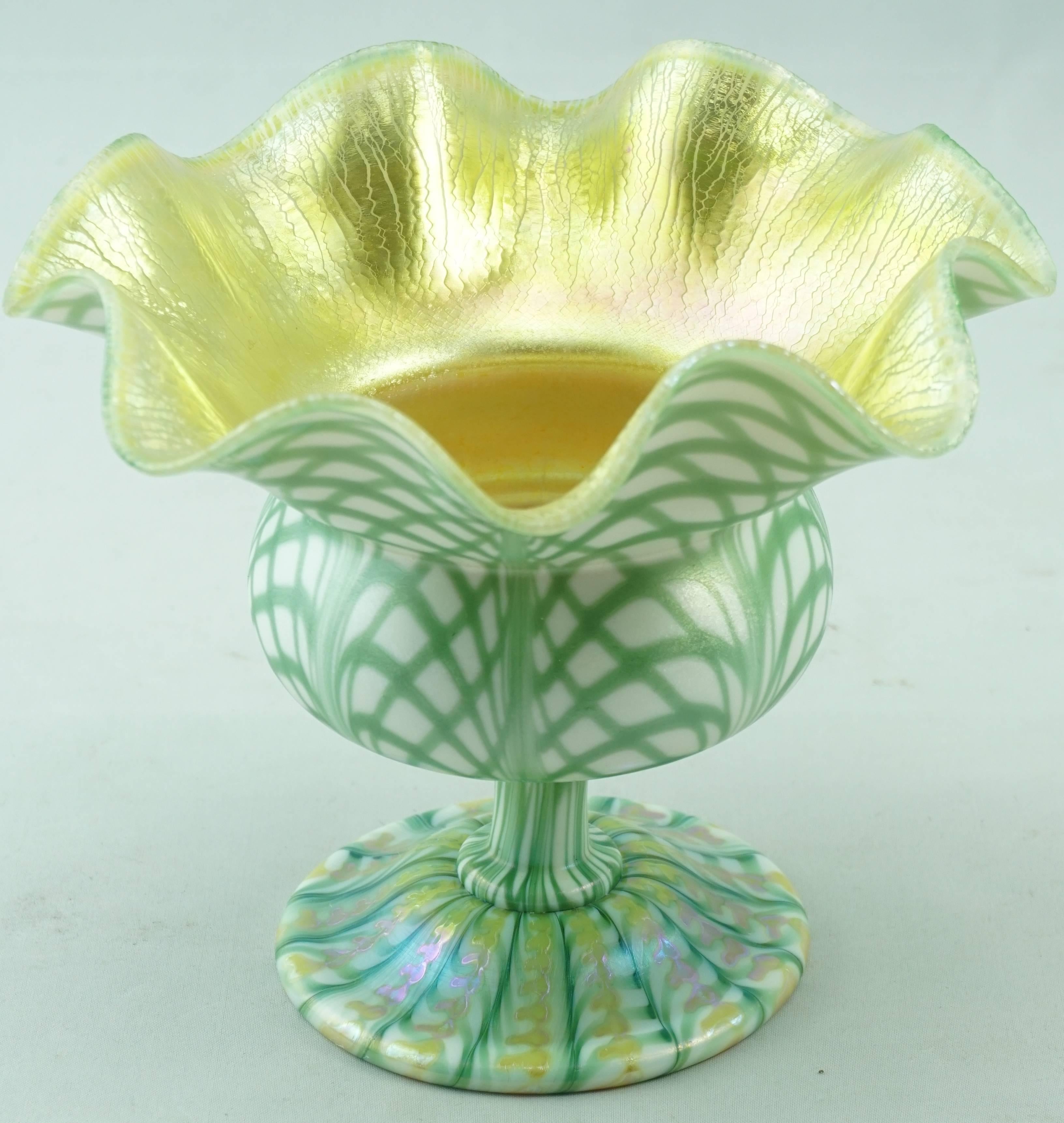 Quezal often did pulled feather decorations, but rarely did fishnet decoration on vases. The base has a gold iridescent zipper decoration. This floriform compote is one of the nicest I've ever had the pleasure of owning. Auspicious size at 4¾