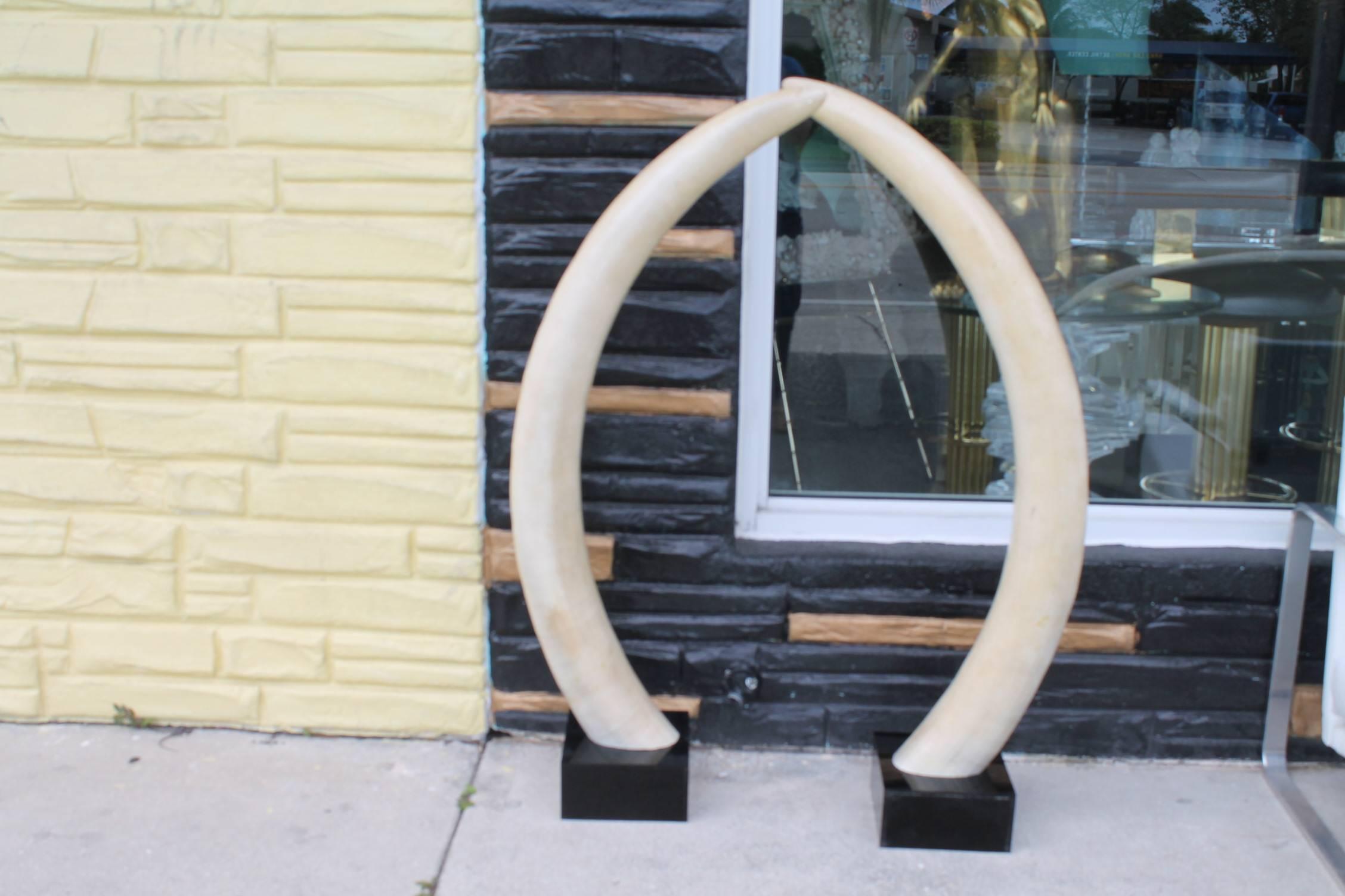 Amazing Vintage Hollywood regency pair of monumental faux elephant tusks mounted on black Lucite panels. The tusks are numbered (see picture).
Base measures 8 x 8. 
