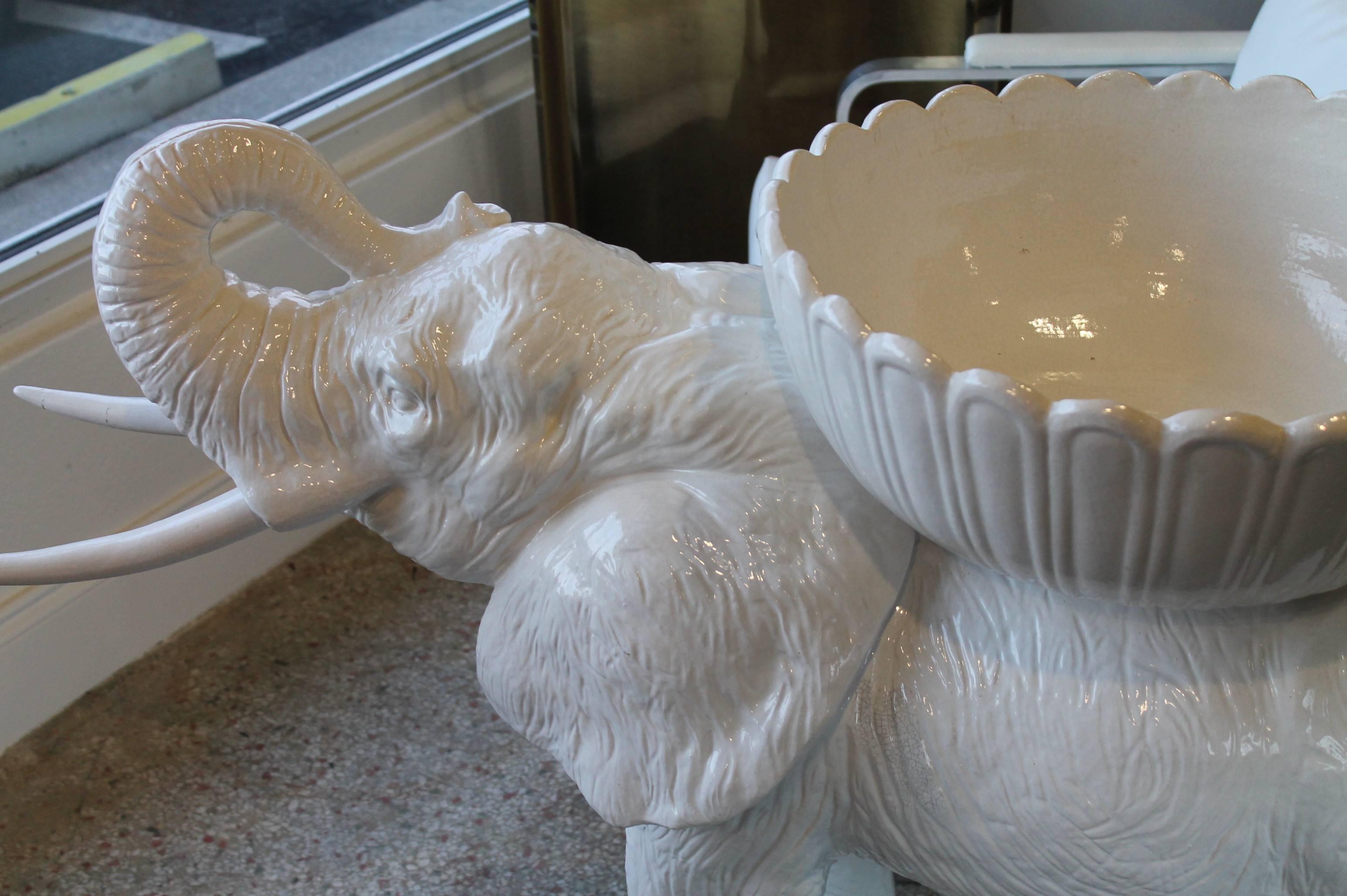 Vintage oversized ceramic elephant planter. From the size, to the tusks, to the incredible details in the wrinkles this exquisite baby elephant is perfect to hold plants, flowers, towels, seashells or even as a photo prop.
