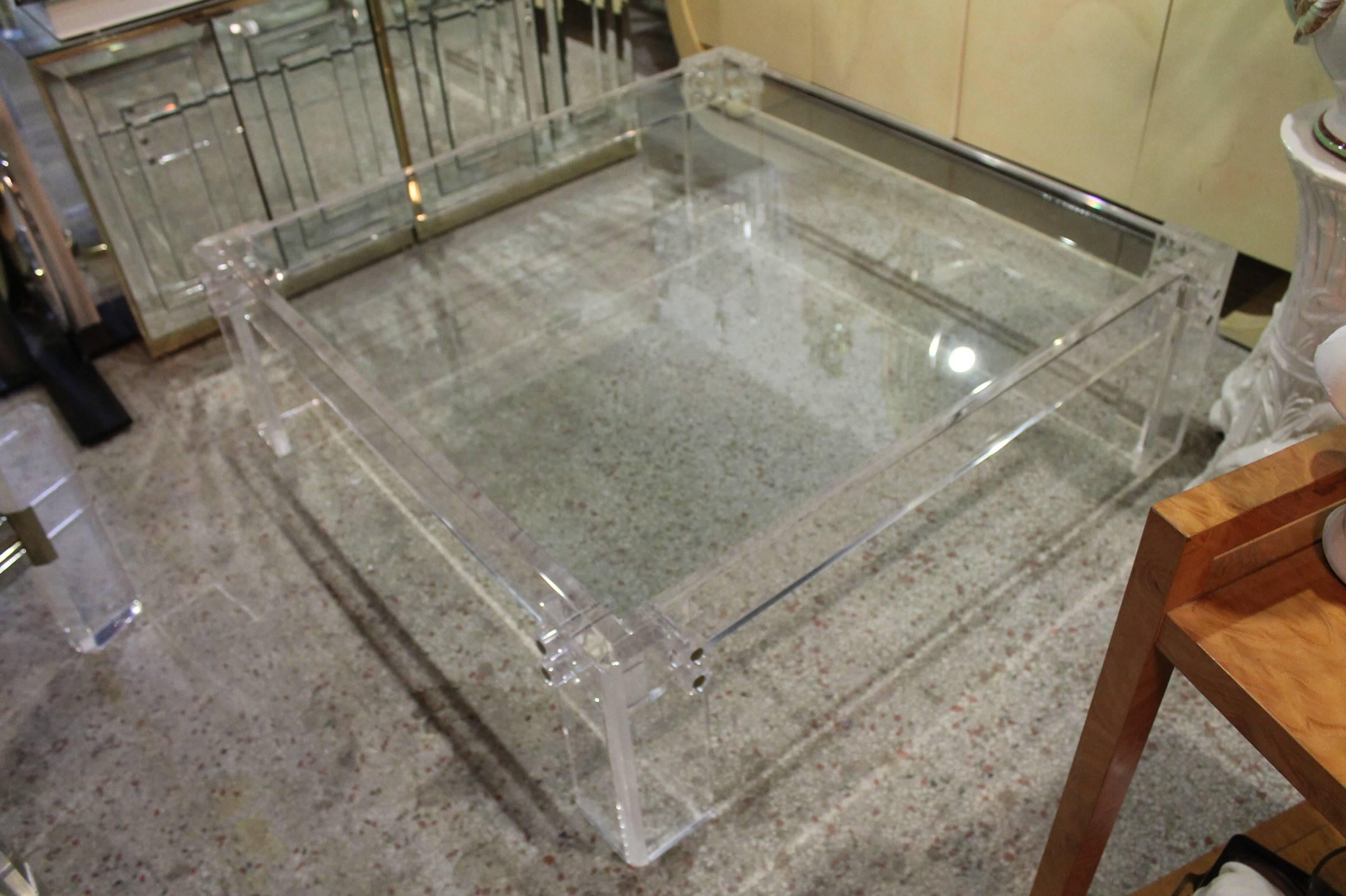 Large square Lucite coffee table with Lucite and chrome pegs. Glass top. Overall size given. Glass top only measures 42 x 42.