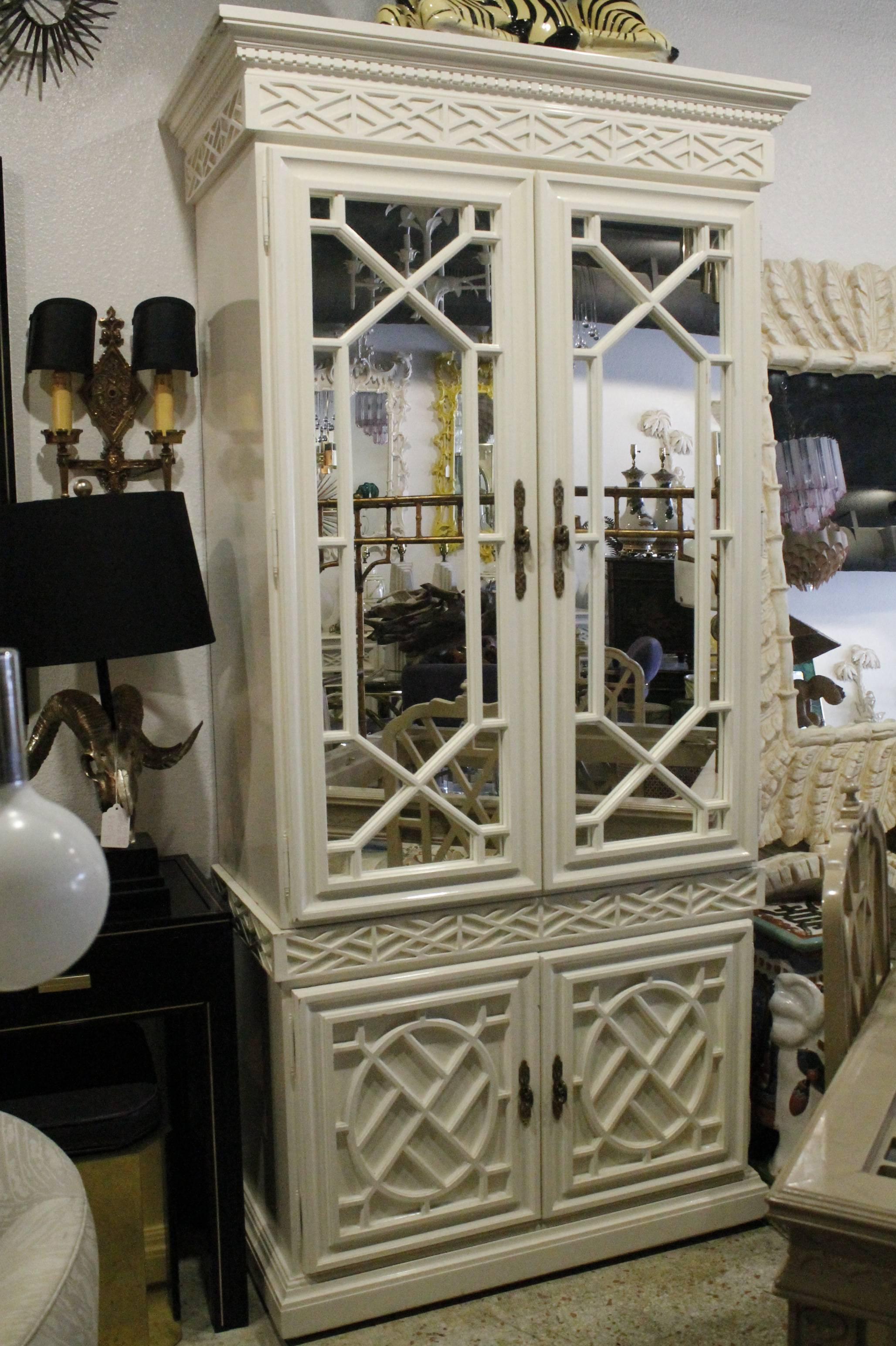 Lovely vintage fretwork mirrored Chinese Chippendale chinoiserie cabinet with shelves, drawer and light inside top cabinet. This can be used for a variety if functions such as a bar cabinet, armoire, china cabinet, tv entertainment center, clothes