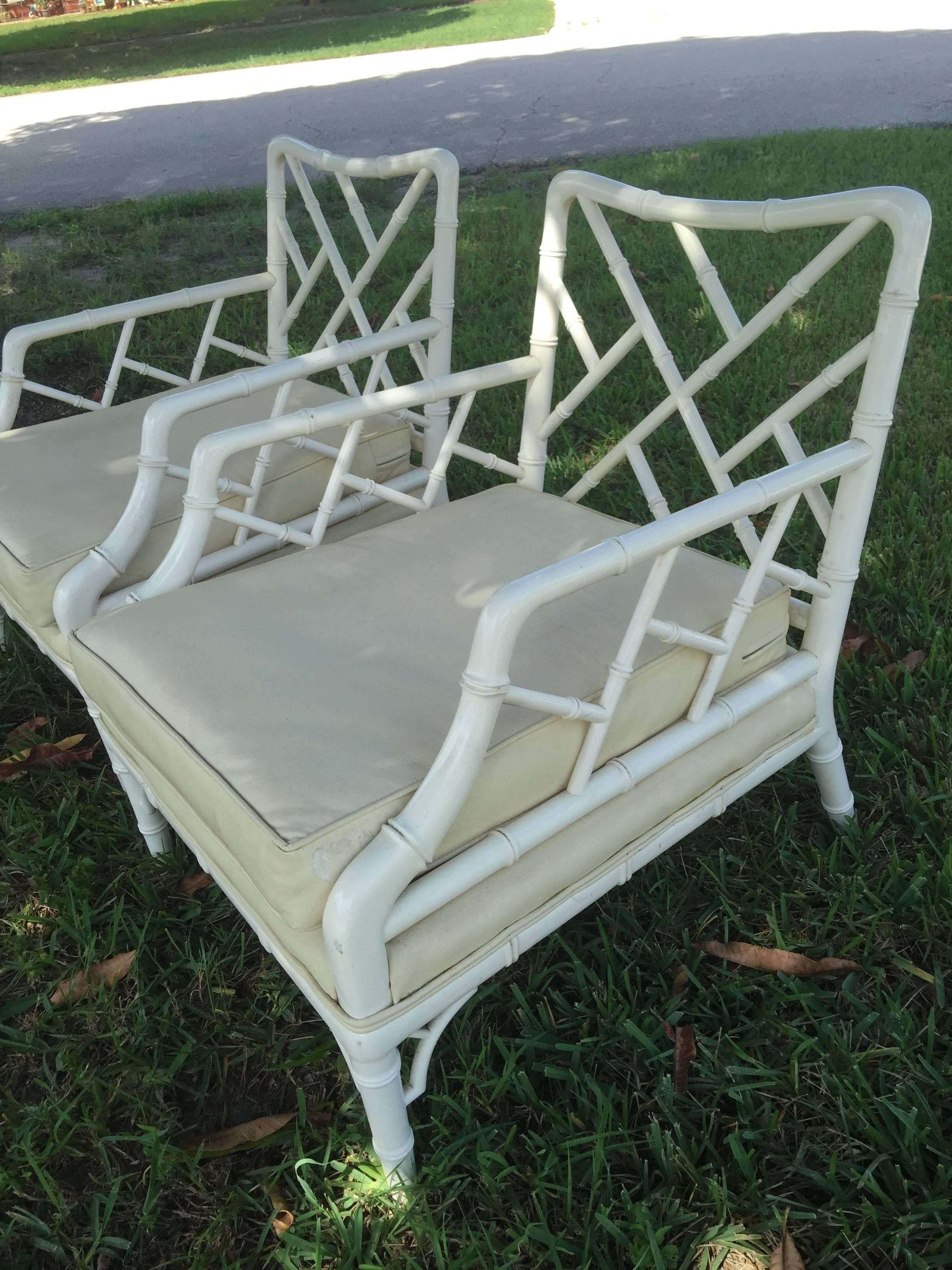 Great pair of vintage faux bamboo Chinese Chippendale chinoiserie club lounge armchairs with fretwork. Original vintage fabric and lacquered finish. Upholstery is faded and had a tear and will need to be re done. The original lacquer finish has some