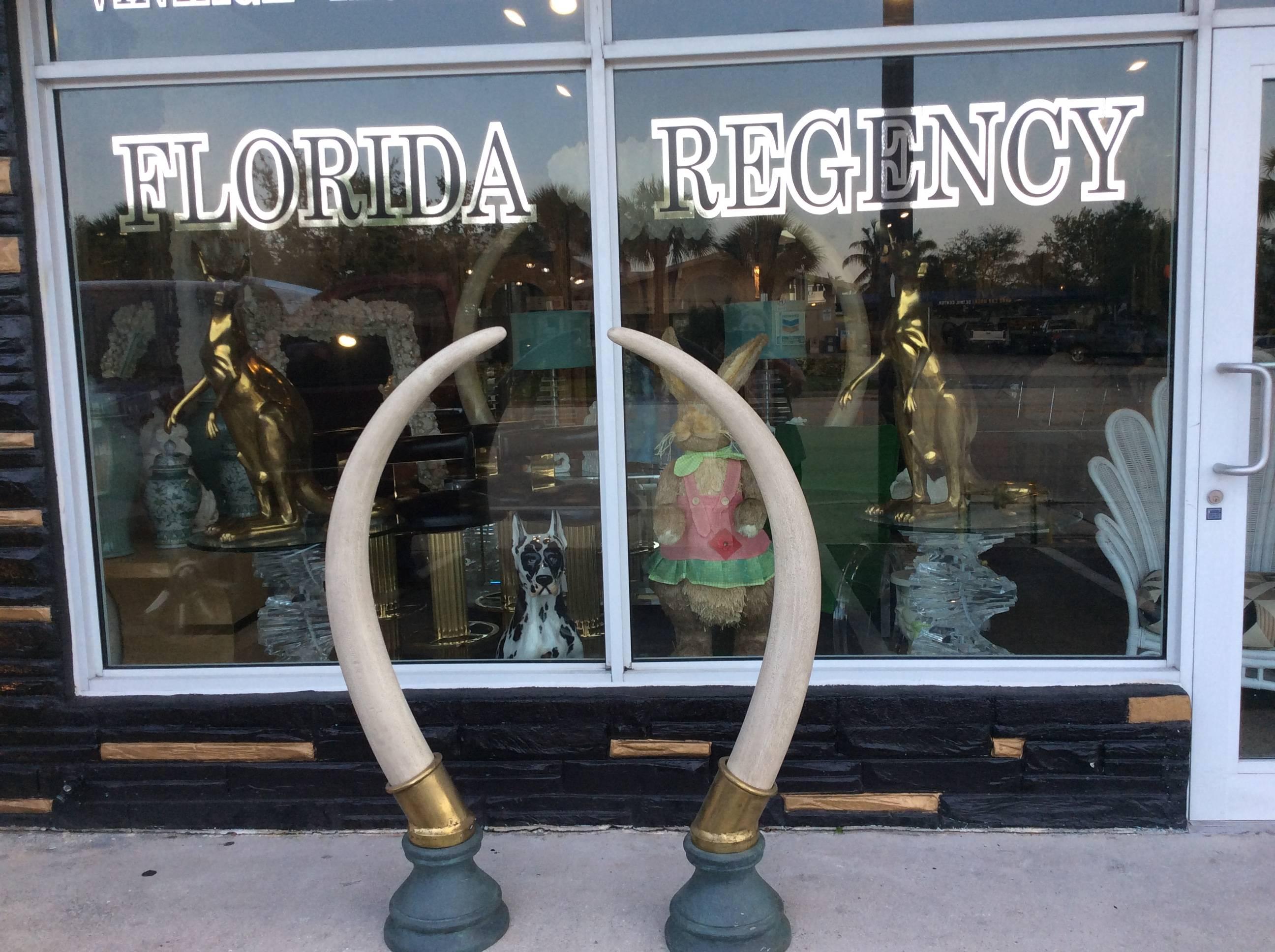 Impressive pair of Vintage Hollywood Regency faux elephant tusks monumental in size. Brass base.

