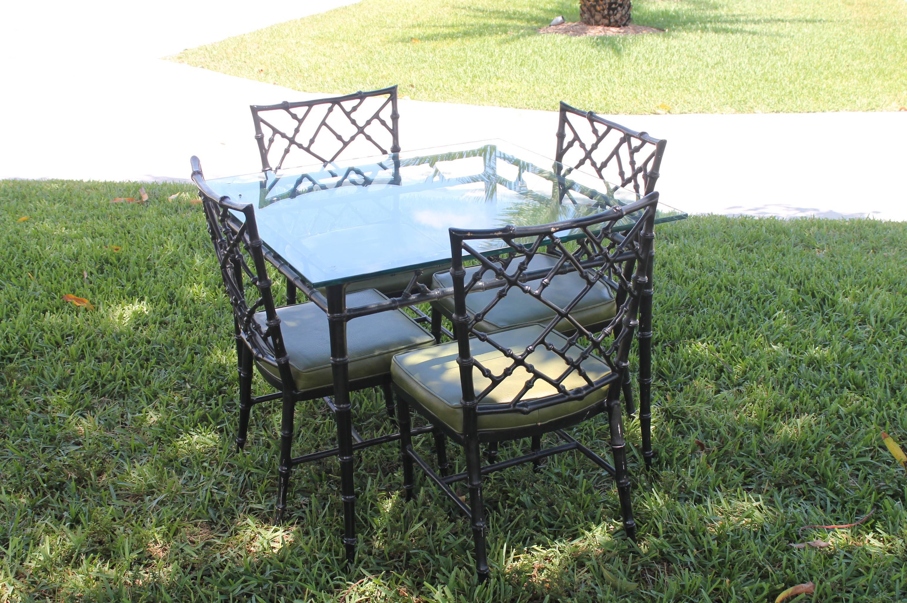Lovely vintage 5 piece Phyllis Morris aluminum metal faux bamboo Chinese Chippendale chinoiserie five-piece patio set which includes dining table with glass top and four side chairs. Original black finish is in excellent condition. Upholstery is